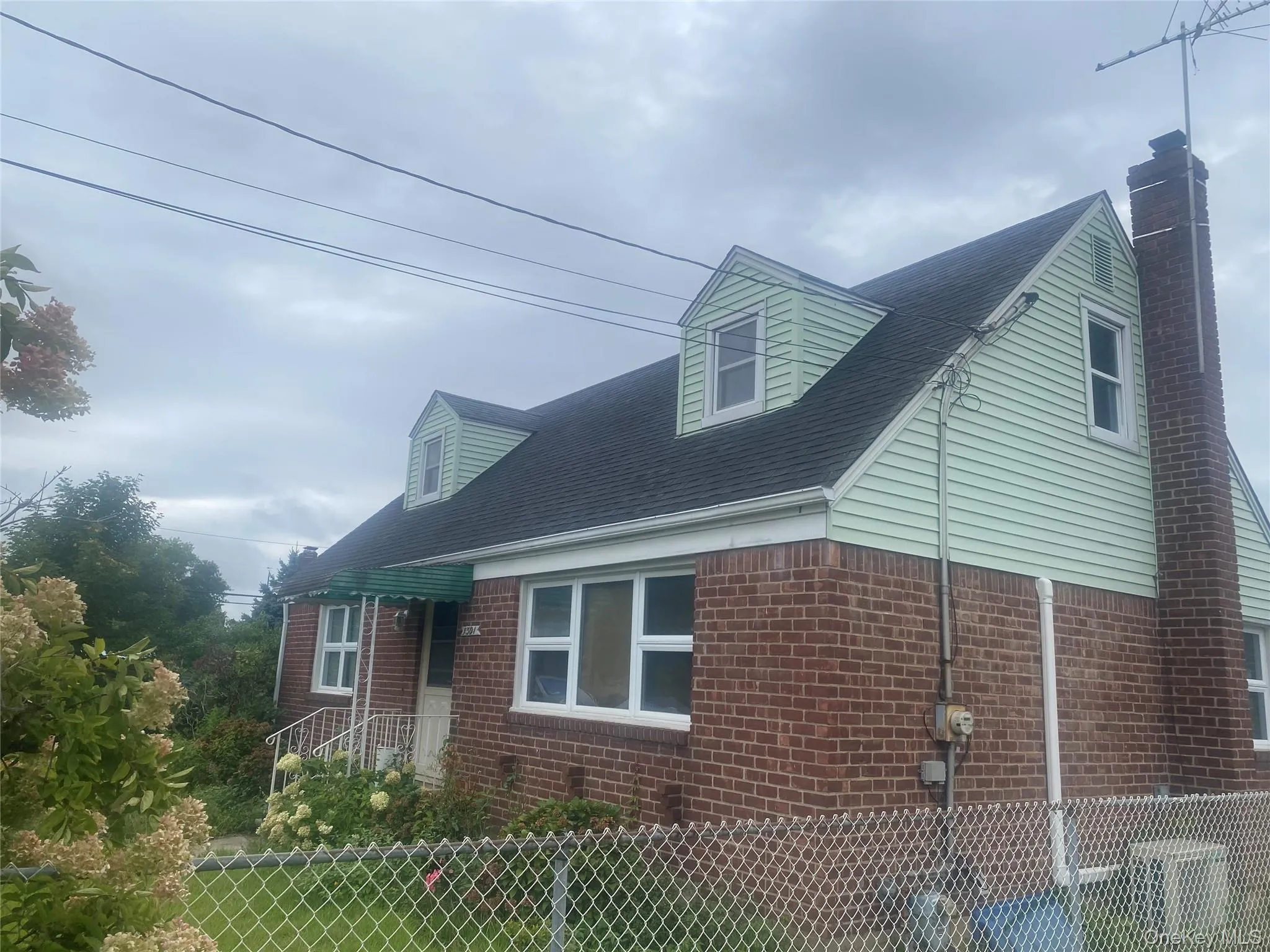 Brick and siding exterior with a dark roof and prominent chimney Brick and siding exterior with a dark roof and prominent chimney