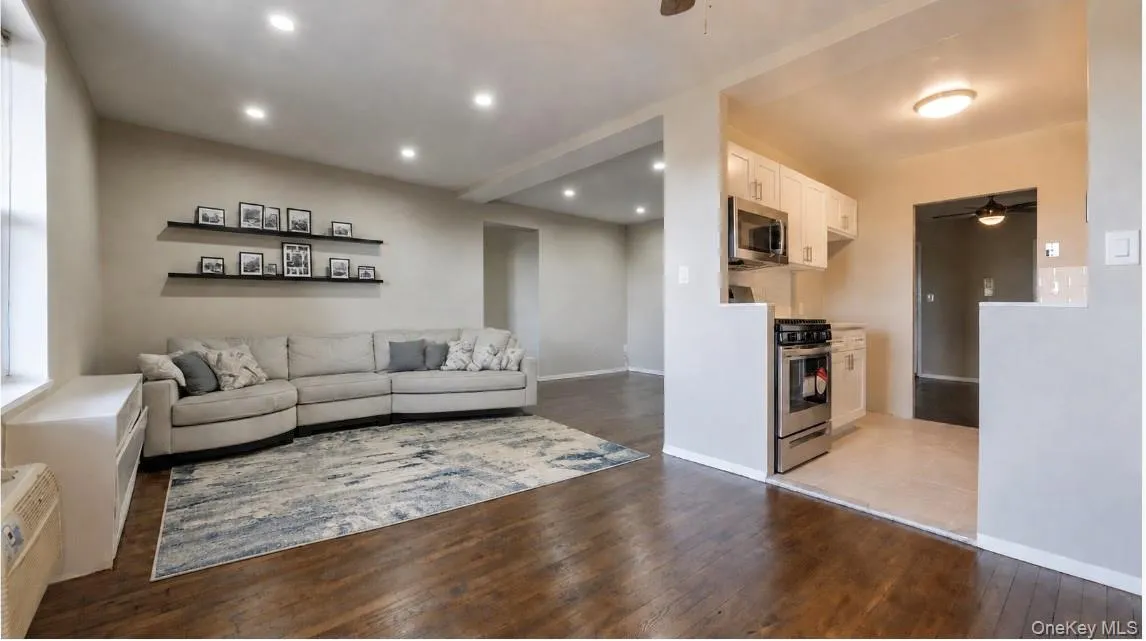 Spacious living room featuring hardwood floors, recessed lighting and a neutral color palette, with an open layout that flows seamlessly into the dining area and kitchen. Spacious living room featuring hardwood floors, recessed lighting and a neutral color palette, with an open layout that flows seamlessly into the dining area and kitchen.