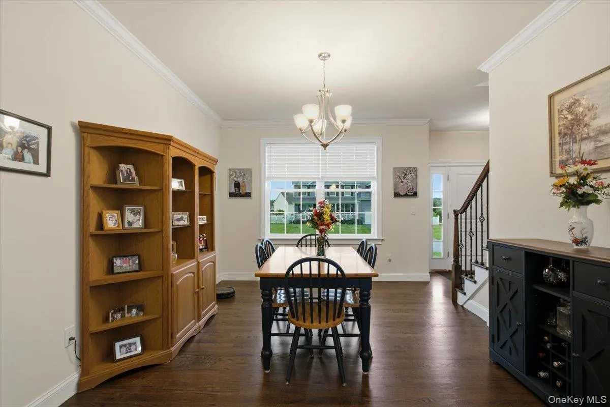 Hardwood flooring, crown molding, double-pane window, staircase with wrought iron balusters, and a built-in shelving unit Hardwood flooring, crown molding, double-pane window, staircase with wrought iron balusters, and a built-in shelving unit