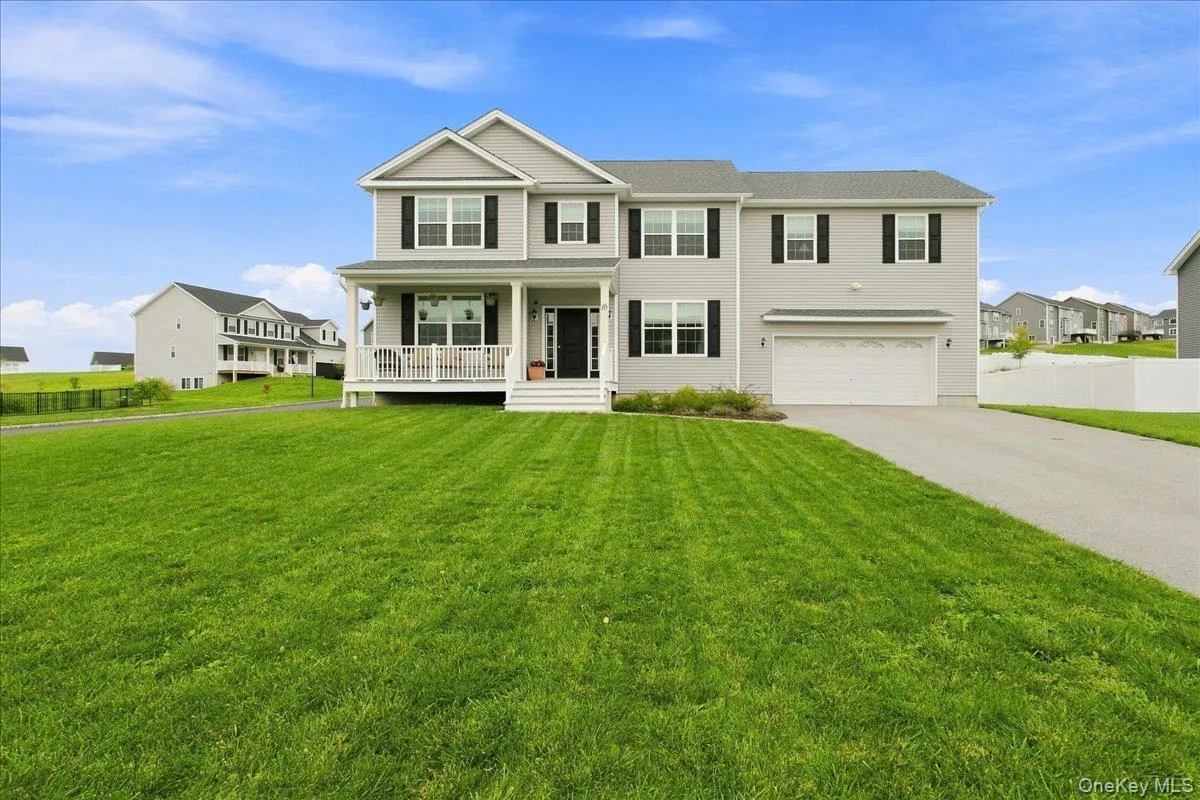 Two-story residence with a covered front porch, attached two-car garage, paved driveway, and expansive front lawn Two-story residence with a covered front porch, attached two-car garage, paved driveway, and expansive front lawn
