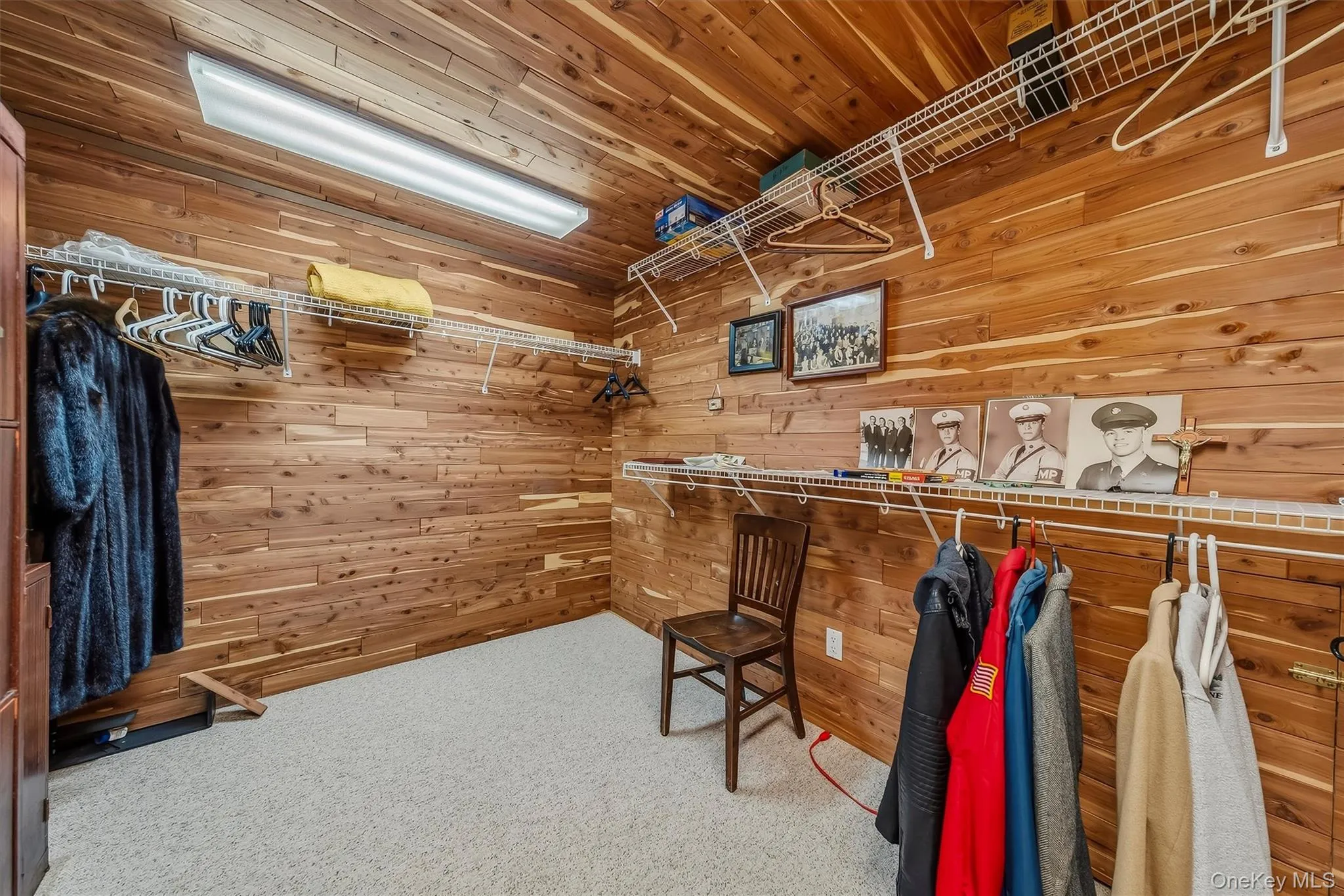 Wood-paneled walls and ceiling, carpeted flooring, and extensive wire shelving Wood-paneled walls and ceiling, carpeted flooring, and extensive wire shelving