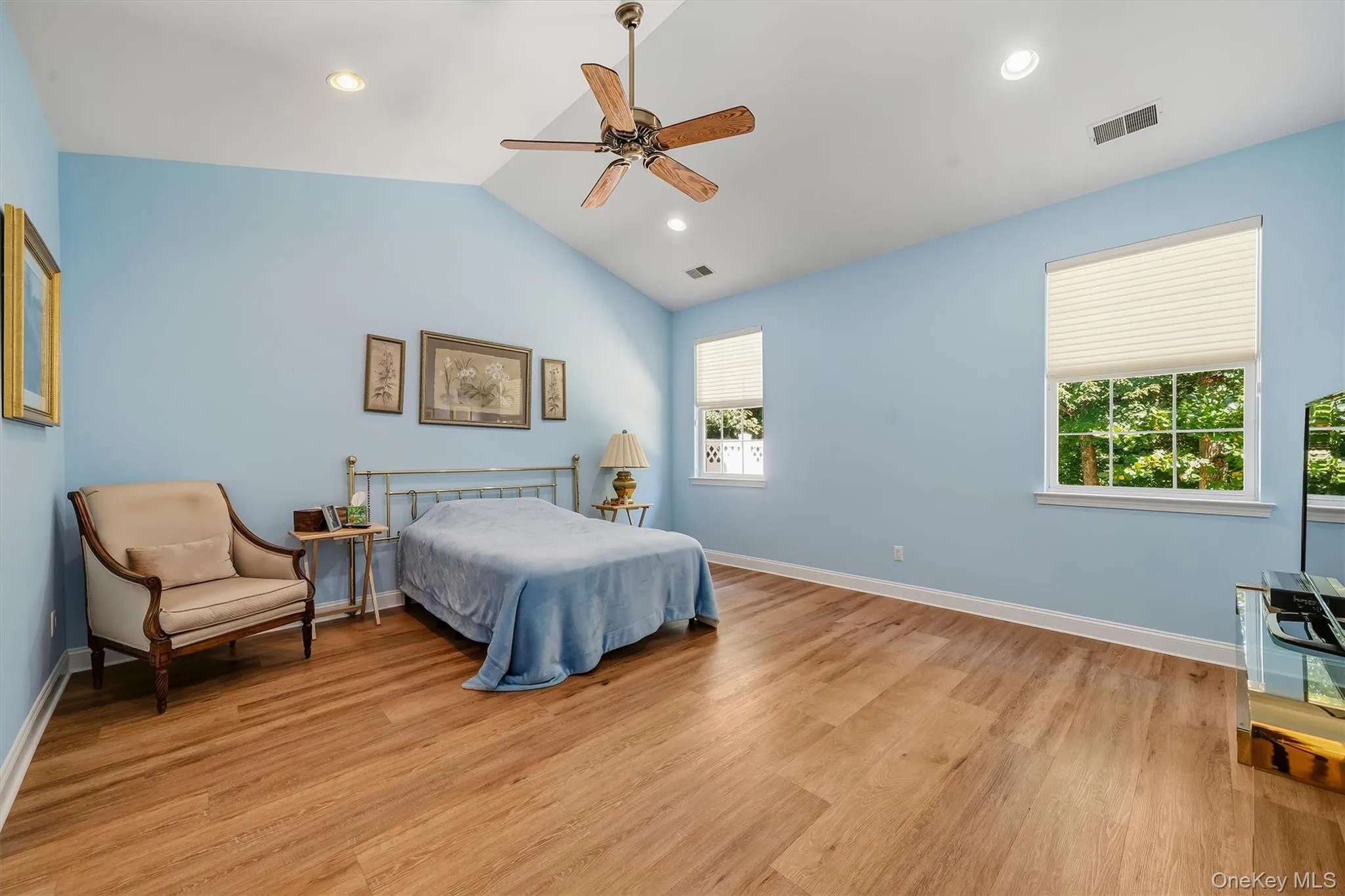 Vaulted ceiling with recessed lighting and a ceiling fan, wood-finish flooring, and multiple windows with privacy blinds Vaulted ceiling with recessed lighting and a ceiling fan, wood-finish flooring, and multiple windows with privacy blinds