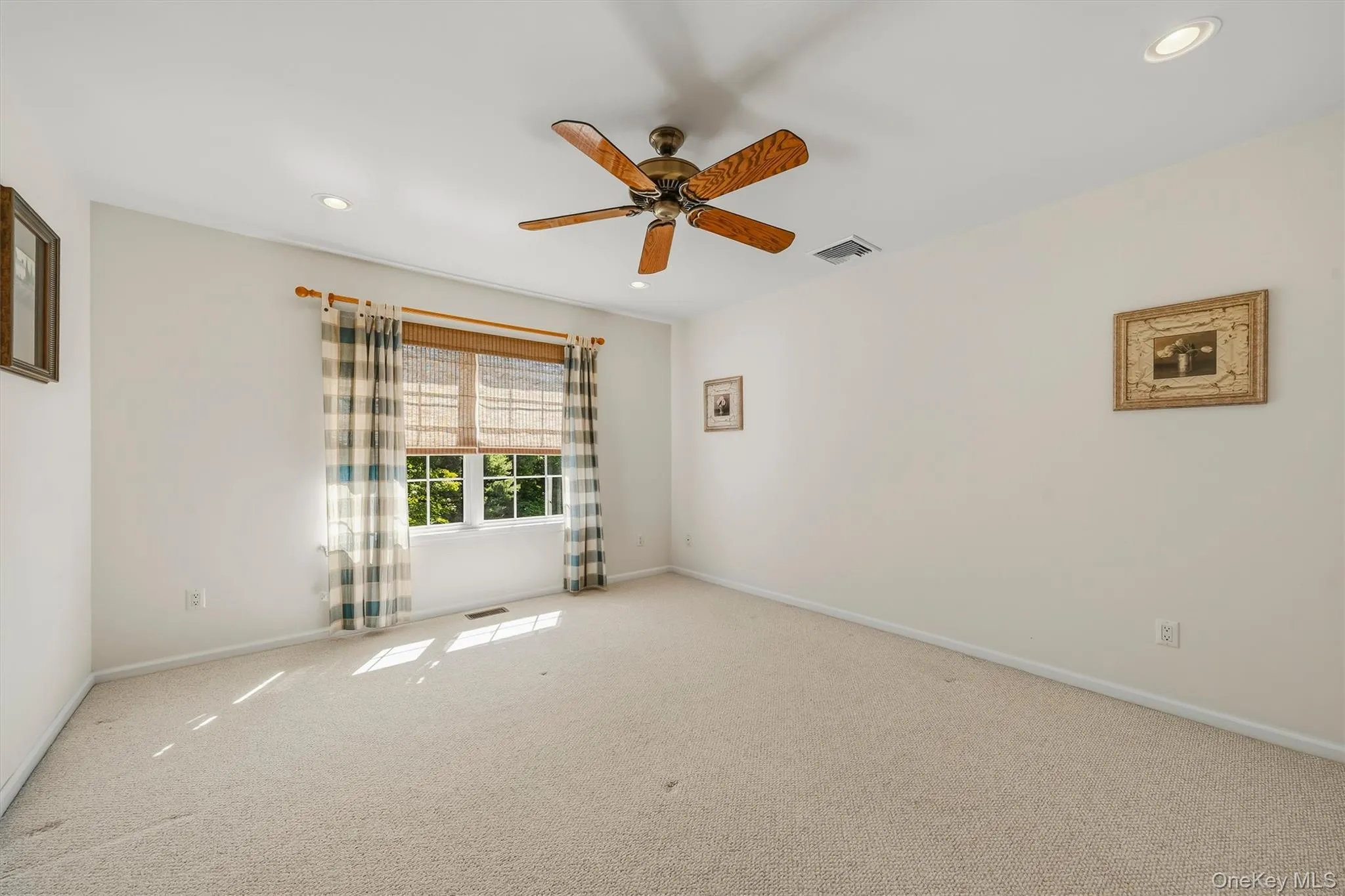 Carpeted room featuring a ceiling fan, recessed lighting, and ample natural light from a double window Carpeted room featuring a ceiling fan, recessed lighting, and ample natural light from a double window