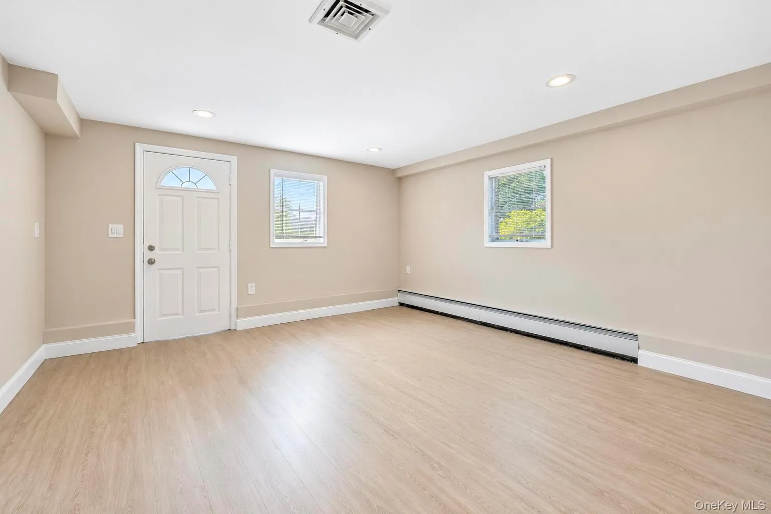 Recessed ceiling lighting, wood-finish flooring, two windows, white trim, and a full-light entry door Recessed ceiling lighting, wood-finish flooring, two windows, white trim, and a full-light entry door