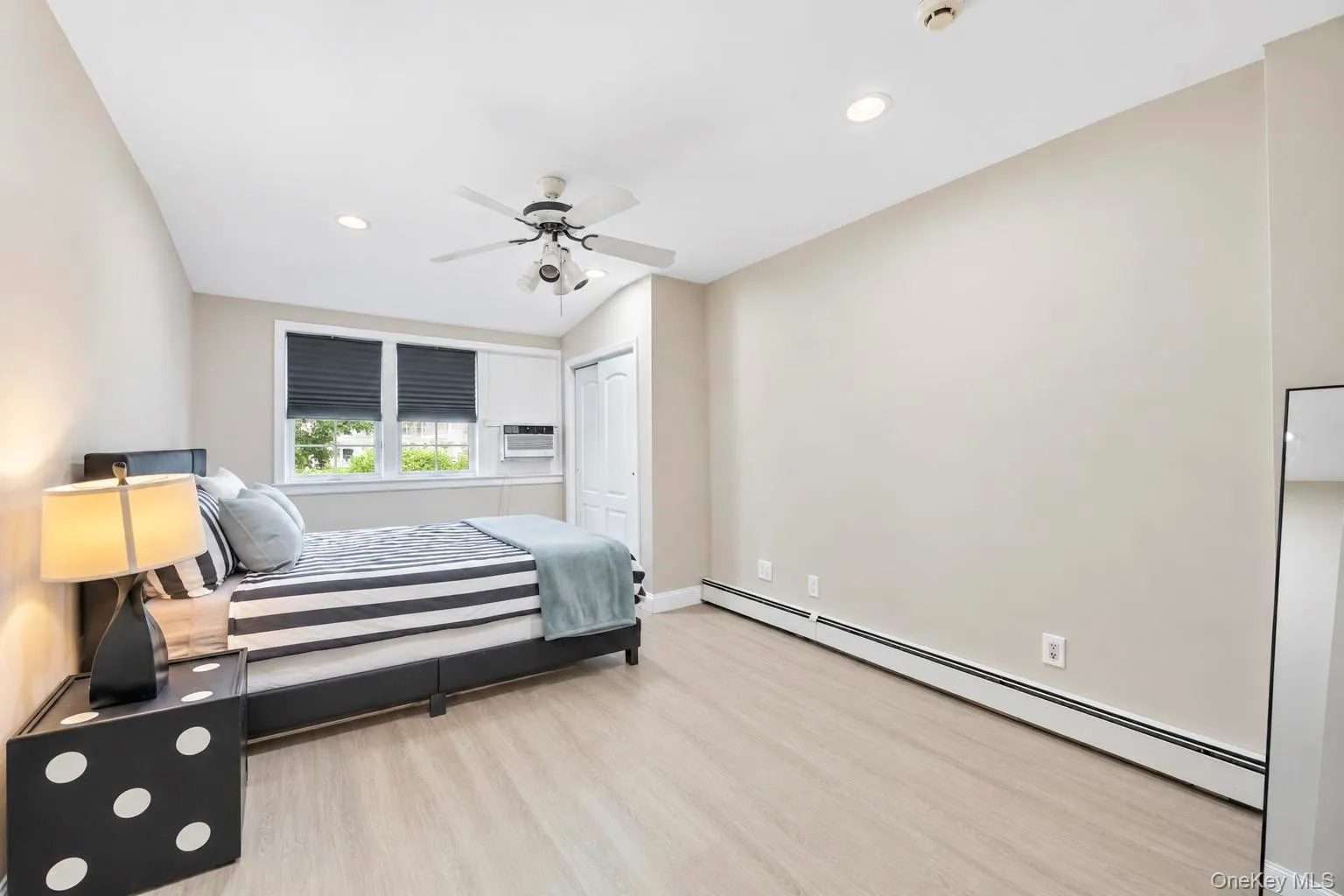 Wood-finish flooring, recessed lighting, and a ceiling fan with light fixture Wood-finish flooring, recessed lighting, and a ceiling fan with light fixture
