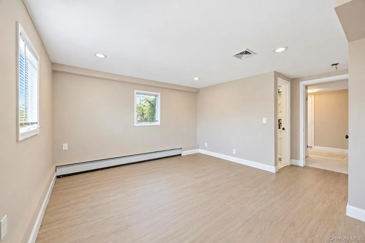 Recessed lighting, light-toned walls, wood-finish flooring, white window trim, and white baseboards Recessed lighting, light-toned walls, wood-finish flooring, white window trim, and white baseboards