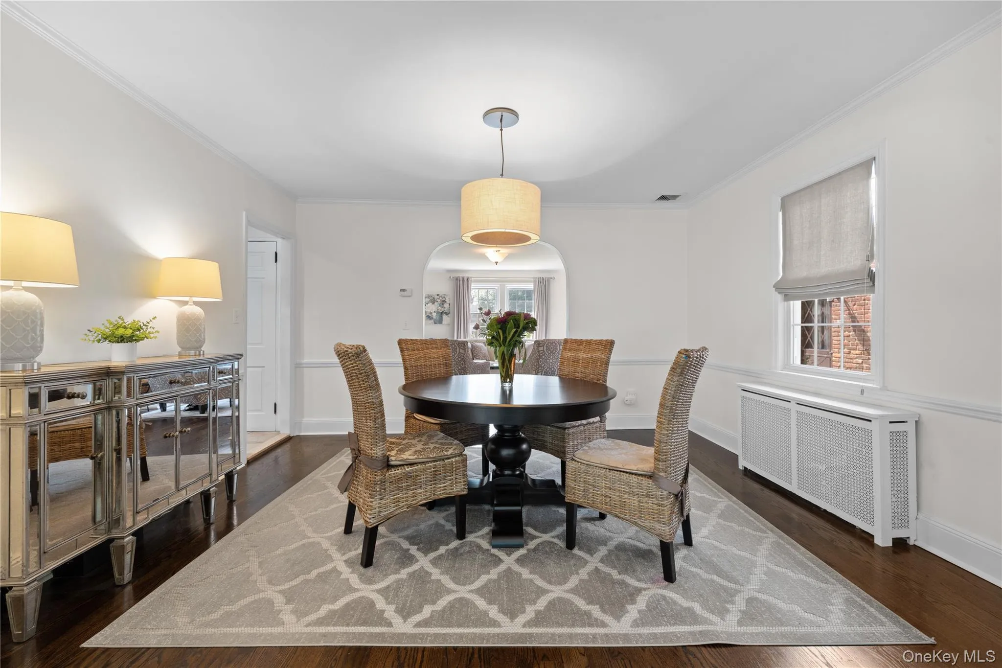 Hardwood flooring, crown molding, arched doorway, window, and a drum pendant light fixture Hardwood flooring, crown molding, arched doorway, window, and a drum pendant light fixture