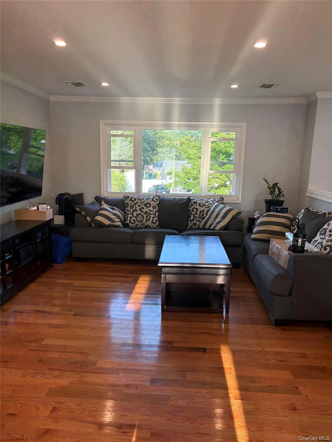 Hardwood flooring, recessed lighting, crown molding, multiple windows, and a large window Hardwood flooring, recessed lighting, crown molding, multiple windows, and a large window