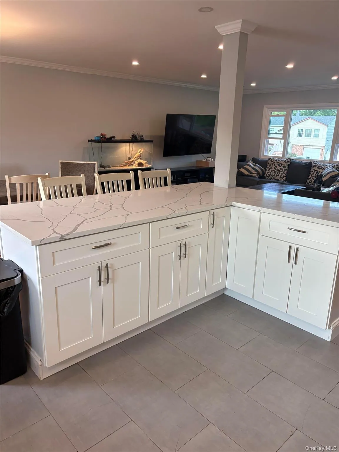 White shaker cabinetry with dark hardware and a light-toned countertop White shaker cabinetry with dark hardware and a light-toned countertop