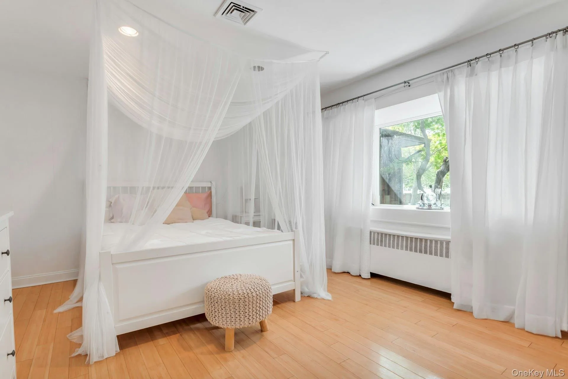 Hardwood flooring, white walls, recessed lighting, and a window with sheer drapes Hardwood flooring, white walls, recessed lighting, and a window with sheer drapes