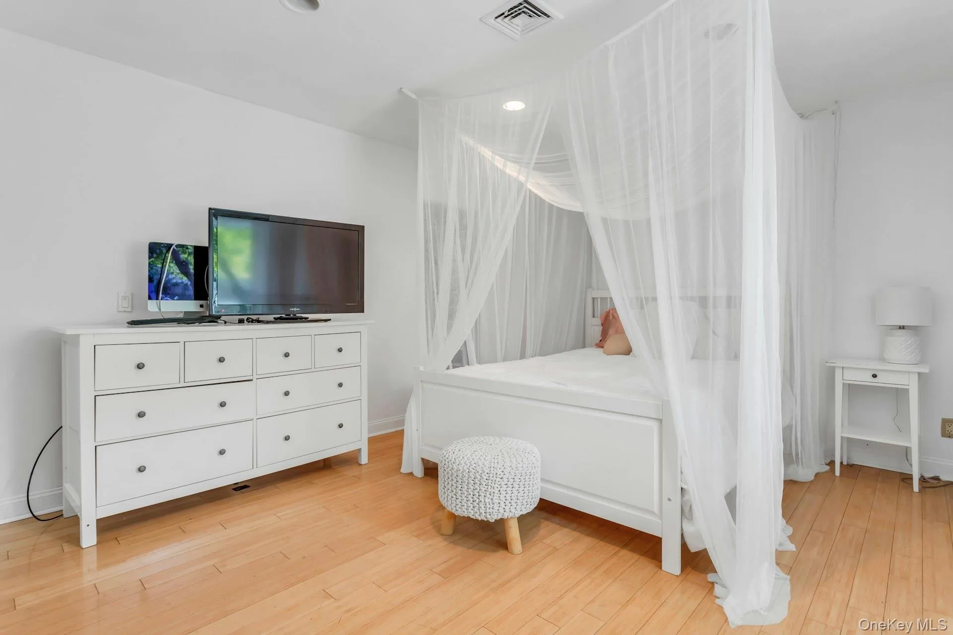 Hardwood flooring, recessed lighting, and bright white walls Hardwood flooring, recessed lighting, and bright white walls