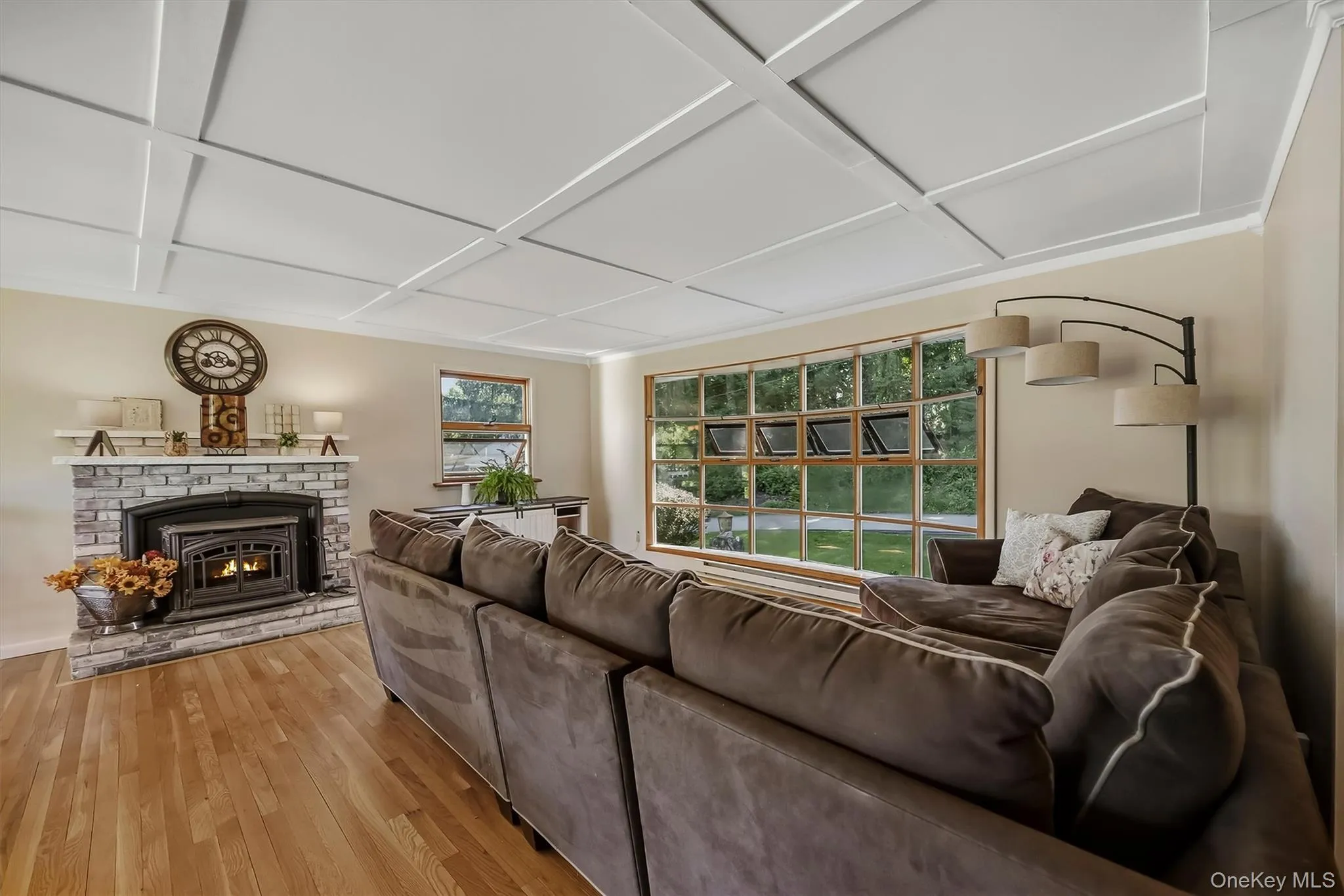 Open concept living room with stacked stone fireplace and pellet stove Open concept living room with stacked stone fireplace and pellet stove