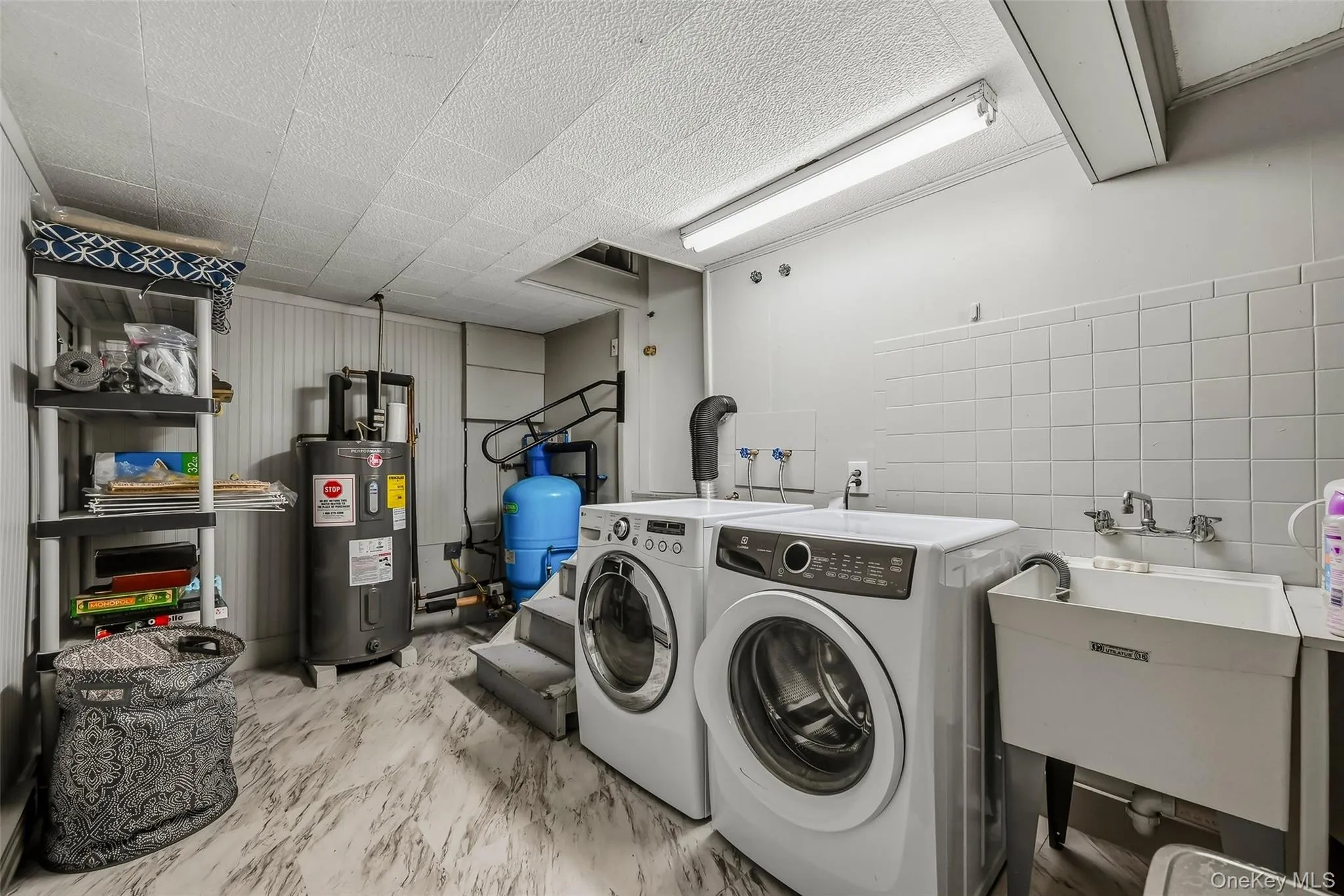 Full size machines and utility area, door to the garage Full size machines and utility area, door to the garage