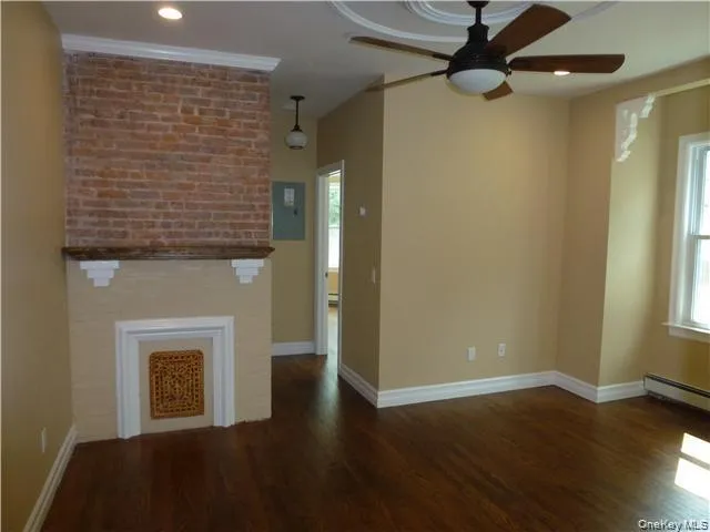 Exposed brick wall, decorative fireplace, rich wood-finish flooring, ceiling fan with integrated lighting, recessed ceiling lighting Exposed brick wall, decorative fireplace, rich wood-finish flooring, ceiling fan with integrated lighting, recessed ceiling lighting