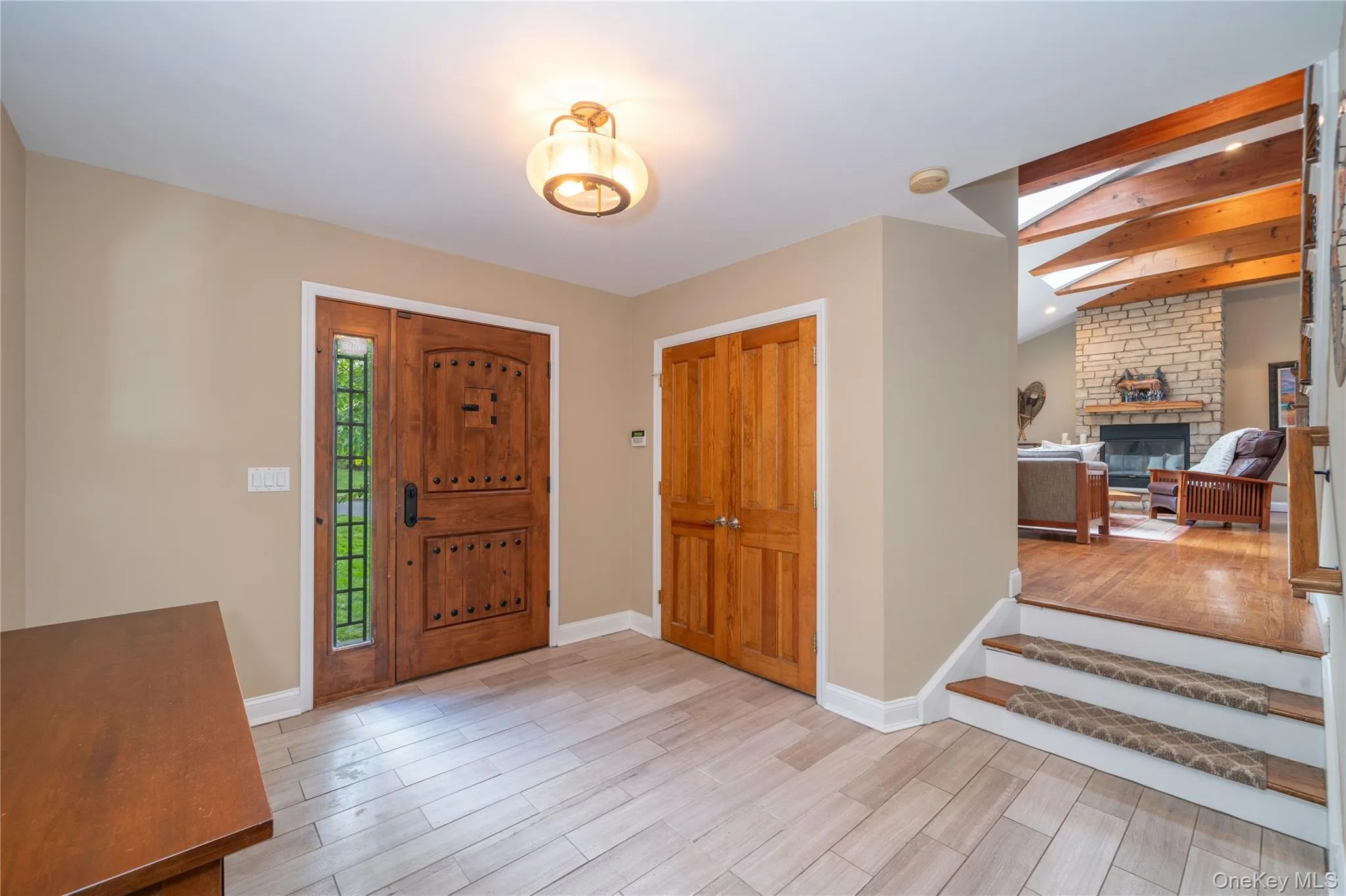 The welcoming entry foyer introduces the home's warm wood details and leads just a few steps up to the dramatic open-concept main living spaces. The welcoming entry foyer introduces the home's warm wood details and leads just a few steps up to the dramatic open-concept main living spaces.