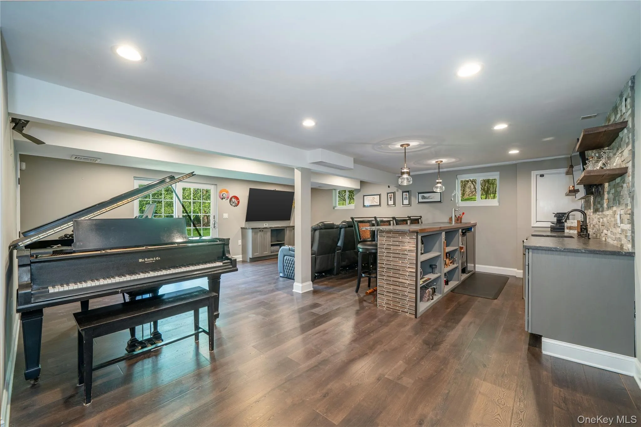An expansive recreation room is deigned for entertaining, with a full bar, movie theatre area, space for a piano and exercise equipment, plus walk-out access to the patio and hot tub. An expansive recreation room is deigned for entertaining, with a full bar, movie theatre area, space for a piano and exercise equipment, plus walk-out access to the patio and hot tub.