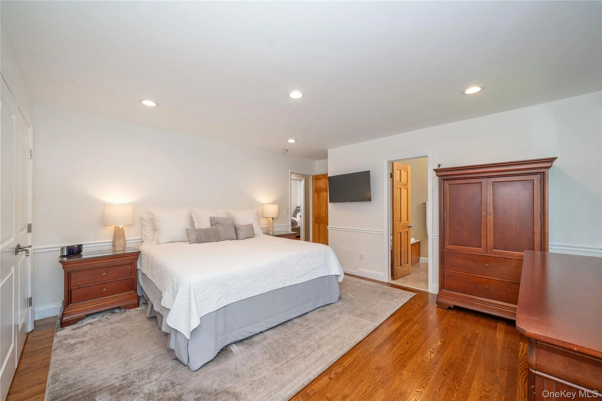 Generously sized primary bedroom with hardwood floors and an en-suite bath. Generously sized primary bedroom with hardwood floors and an en-suite bath.
