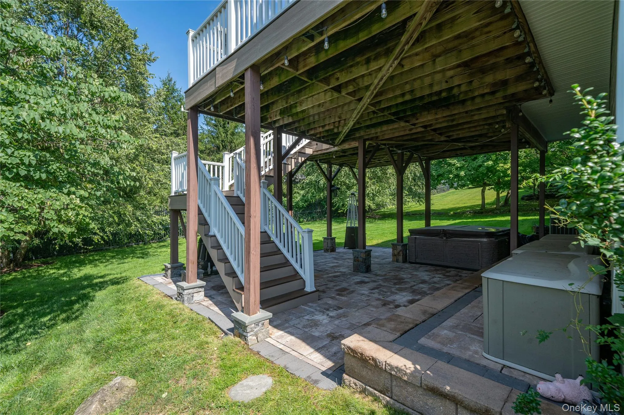 Just outside the recreation room, the patio offers a relaxing outdoor retreat with a hot tub and easy access to the backyard, while a staircase connects directly to the expansive deck above. Just outside the recreation room, the patio offers a relaxing outdoor retreat with a hot tub and easy access to the backyard, while a staircase connects directly to the expansive deck above.