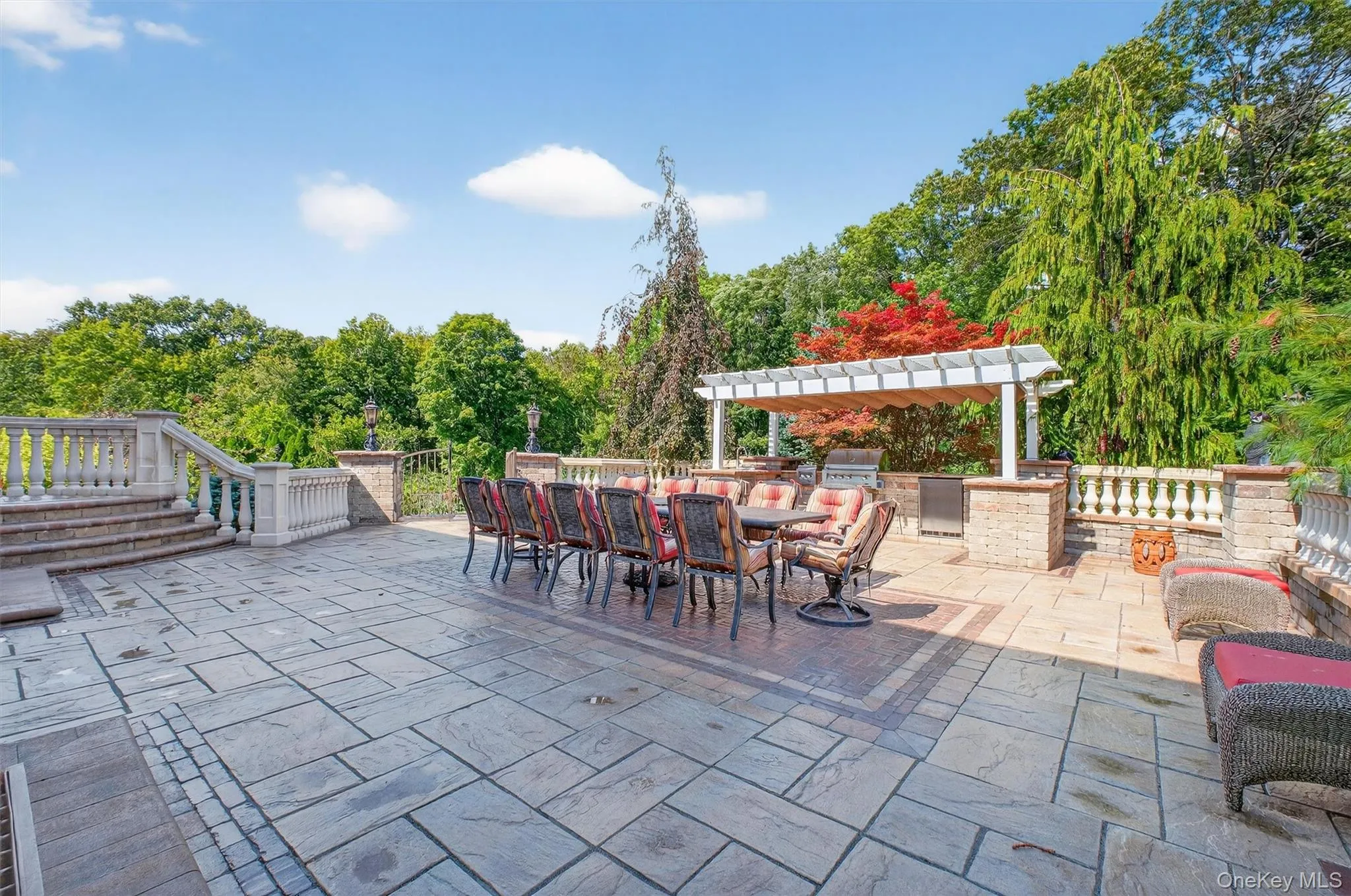 This massive entertainer’s patio sets the stage for gatherings large and small, with a grand dining table that comfortably seats 12—truly reminiscent of the Last Supper. The paver flooring accented with stone coping and elegant ornamental European-style railings creates a timeless, old-world vibe, while stone pillars topped with lighting add both ambiance and function. A built-in outdoor kitchen featuring a grill, refrigerator, and sink rests beneath a charming trellis, making al fresco dining effortless. With direct access from the driveway, main kitchen, and the pool area below, this space is as practical as it is spectacular—perfect for hosting unforgettable evenings under the open sky. This massive entertainer’s patio sets the stage for gatherings large and small, with a grand dining table that comfortably seats 12—truly reminiscent of the Last Supper. The paver flooring accented with stone coping and elegant ornamental European-style railings creates a timeless, old-world vibe, while stone pillars topped with lighting add both ambiance and function. A built-in outdoor kitchen featuring a grill, refrigerator, and sink rests beneath a charming trellis, making al fresco dining effortless. With direct access from the driveway, main kitchen, and the pool area below, this space is as practical as it is spectacular—perfect for hosting unforgettable evenings under the open sky.