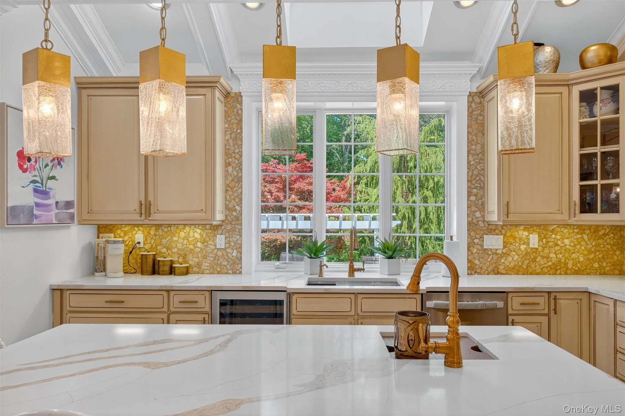This kitchen is anchored by two striking features—the grand center island and the sunlit garden window. The island, finished with sleek quartz surfaces and accented by designer pendant lighting, provides generous seating and workspace, making it as stylish as it is functional. Opposite, the garden window frames lush outdoor views, bathing the room in natural light and creating a bright focal point over the sink. Surrounding these statement pieces, custom cabinetry offers abundant storage, while professional-grade appliances blend seamlessly into the design. Every detail, from the coffered ceiling above to the polished finishes throughout, reflects a thoughtful balance of elegance and everyday convenience. This kitchen is anchored by two striking features—the grand center island and the sunlit garden window. The island, finished with sleek quartz surfaces and accented by designer pendant lighting, provides generous seating and workspace, making it as stylish as it is functional. Opposite, the garden window frames lush outdoor views, bathing the room in natural light and creating a bright focal point over the sink. Surrounding these statement pieces, custom cabinetry offers abundant storage, while professional-grade appliances blend seamlessly into the design. Every detail, from the coffered ceiling above to the polished finishes throughout, reflects a thoughtful balance of elegance and everyday convenience.