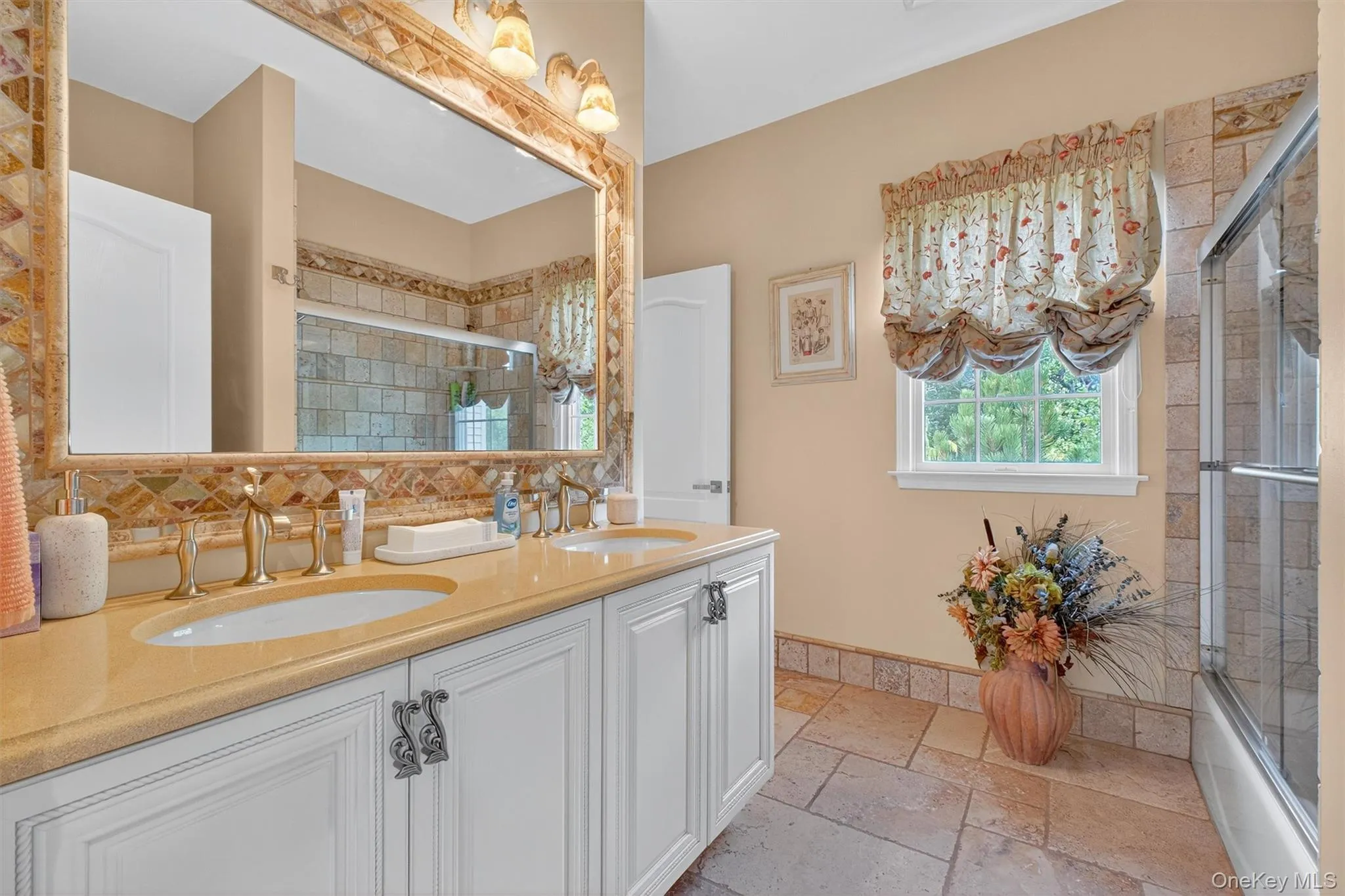 Step into the attached private bathroom of the Prince/Princess suite, where abundant natural light pours in through expansive windows, illuminating every elegant detail. This generously sized retreat features a stunning double vanity with two sinks, each adorned with gleaming gold faucets that lend a regal touch to the space. A custom mirror stretches gracefully above the vanity, reflecting the soft morning light and amplifying the sense of openness. The luxurious tub is finished with exquisite Botticino tile, offering both beauty and durability, while sleek glass shower doors enclose a spacious shower area, creating a contemporary yet timeless oasis. Here, comfort and sophistication blend effortlessly, making every moment in this bath feel truly extraordinary. Step into the attached private bathroom of the Prince/Princess suite, where abundant natural light pours in through expansive windows, illuminating every elegant detail. This generously sized retreat features a stunning double vanity with two sinks, each adorned with gleaming gold faucets that lend a regal touch to the space. A custom mirror stretches gracefully above the vanity, reflecting the soft morning light and amplifying the sense of openness. The luxurious tub is finished with exquisite Botticino tile, offering both beauty and durability, while sleek glass shower doors enclose a spacious shower area, creating a contemporary yet timeless oasis. Here, comfort and sophistication blend effortlessly, making every moment in this bath feel truly extraordinary.