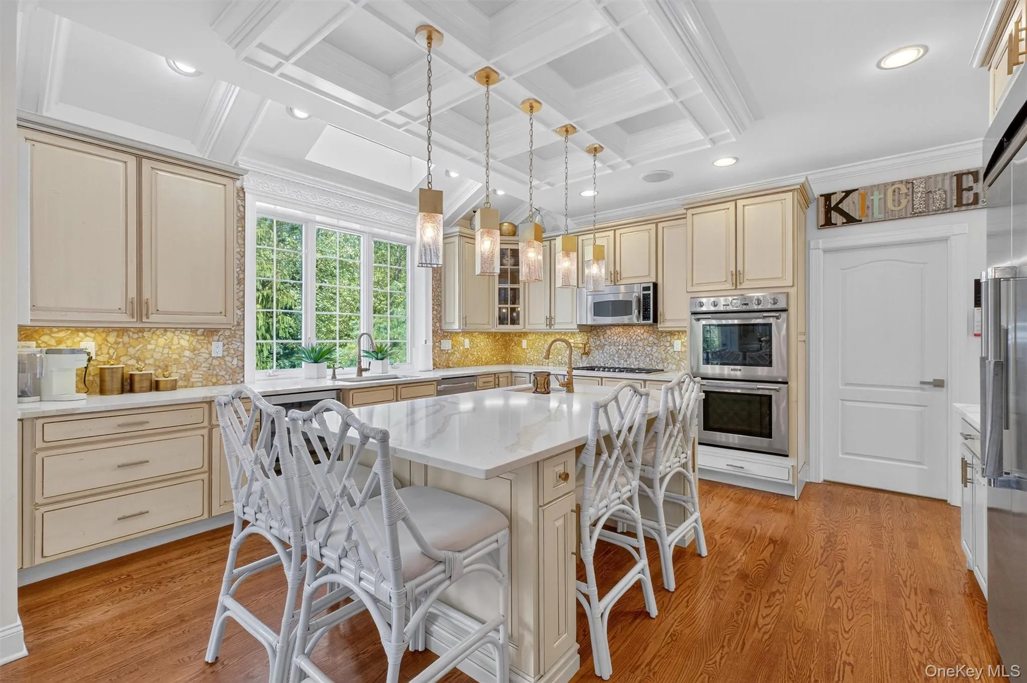 This kitchen is straight out of an HGTV dream—designed to impress while delivering everyday functionality. At its center is a massive eat-in island with gorgeous quartz countertops, offering seating for four and plenty of prep space. The coffered ceiling adds architectural elegance, beautifully complemented by chic pendant lighting that sets a warm, inviting glow. A garden window frames the sink, bringing in natural light and views of the outdoors, while the sleek stainless-steel appliances provide all the modern conveniences a chef could ever want. From its thoughtful design to its high-end finishes, this kitchen truly has it all. This kitchen is straight out of an HGTV dream—designed to impress while delivering everyday functionality. At its center is a massive eat-in island with gorgeous quartz countertops, offering seating for four and plenty of prep space. The coffered ceiling adds architectural elegance, beautifully complemented by chic pendant lighting that sets a warm, inviting glow. A garden window frames the sink, bringing in natural light and views of the outdoors, while the sleek stainless-steel appliances provide all the modern conveniences a chef could ever want. From its thoughtful design to its high-end finishes, this kitchen truly has it all.