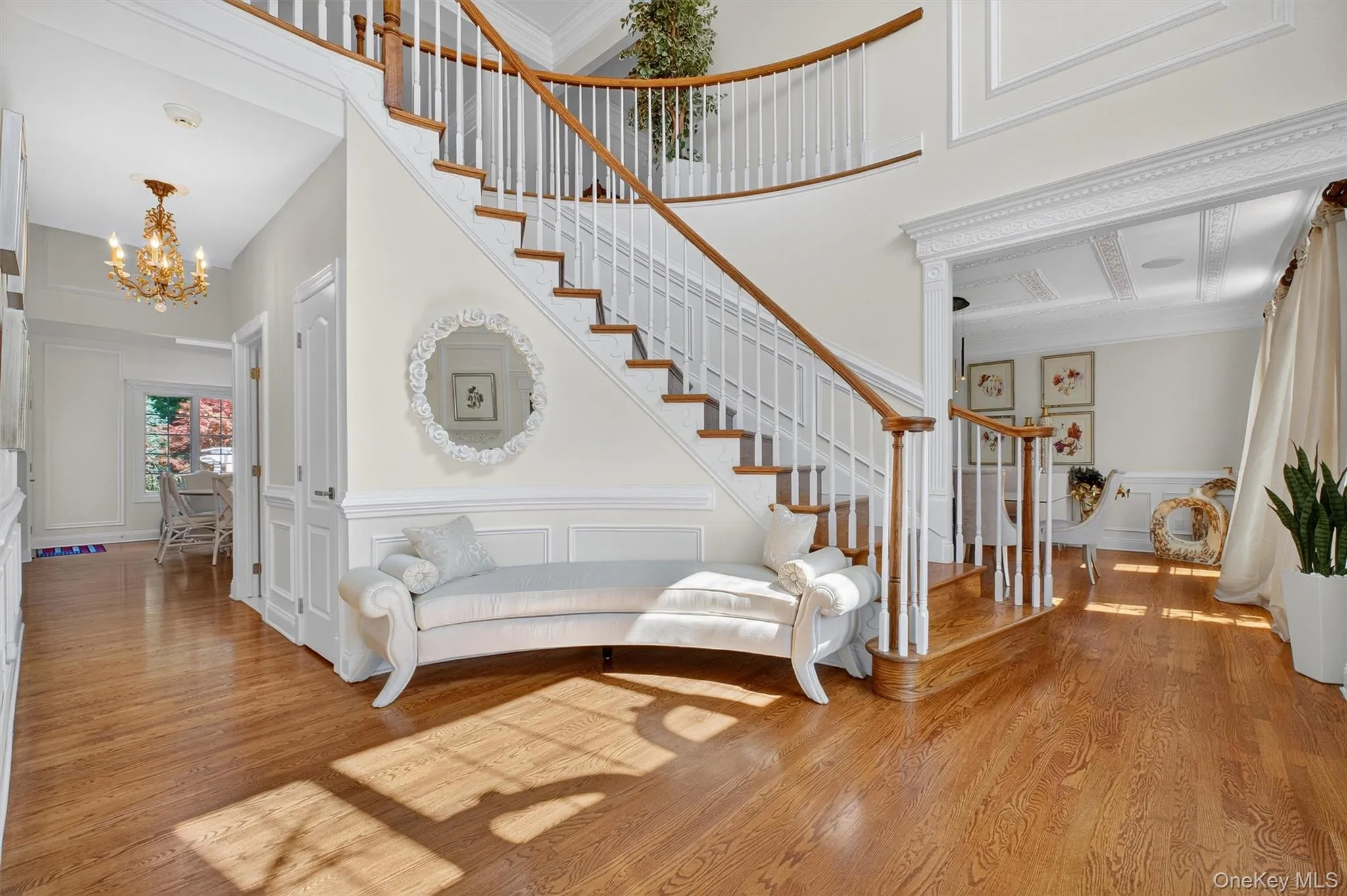 Step into the grand entryway of this exquisite contemporary Colonial and immediately feel the elegance and craftsmanship that defines over 6,000 square feet of luxurious living. This light-filled, incredibly spacious two-story foyer is oversized and completely open, allowing sweeping views of nearly every room on the first floor and up to the second floor above. Showcasing one of the home’s dual staircases, the foyer is adorned with a GLORIOUS chandelier that pairs beautifully with the gleaming pristine hardwood floors. Freshly painted in a sophisticated neutral palette, the space is framed by custom wall panels and rich crown molding, offering a timeless backdrop for both everyday living and formal entertaining. Seamlessly connecting to multiple living areas, and a layout that invites effortless flow throughout the first floor. From the moment you arrive, this home makes a bold statement of quality, style, and comfort. Step into the grand entryway of this exquisite contemporary Colonial and immediately feel the elegance and craftsmanship that defines over 6,000 square feet of luxurious living. This light-filled, incredibly spacious two-story foyer is oversized and completely open, allowing sweeping views of nearly every room on the first floor and up to the second floor above. Showcasing one of the home’s dual staircases, the foyer is adorned with a GLORIOUS chandelier that pairs beautifully with the gleaming pristine hardwood floors. Freshly painted in a sophisticated neutral palette, the space is framed by custom wall panels and rich crown molding, offering a timeless backdrop for both everyday living and formal entertaining. Seamlessly connecting to multiple living areas, and a layout that invites effortless flow throughout the first floor. From the moment you arrive, this home makes a bold statement of quality, style, and comfort.