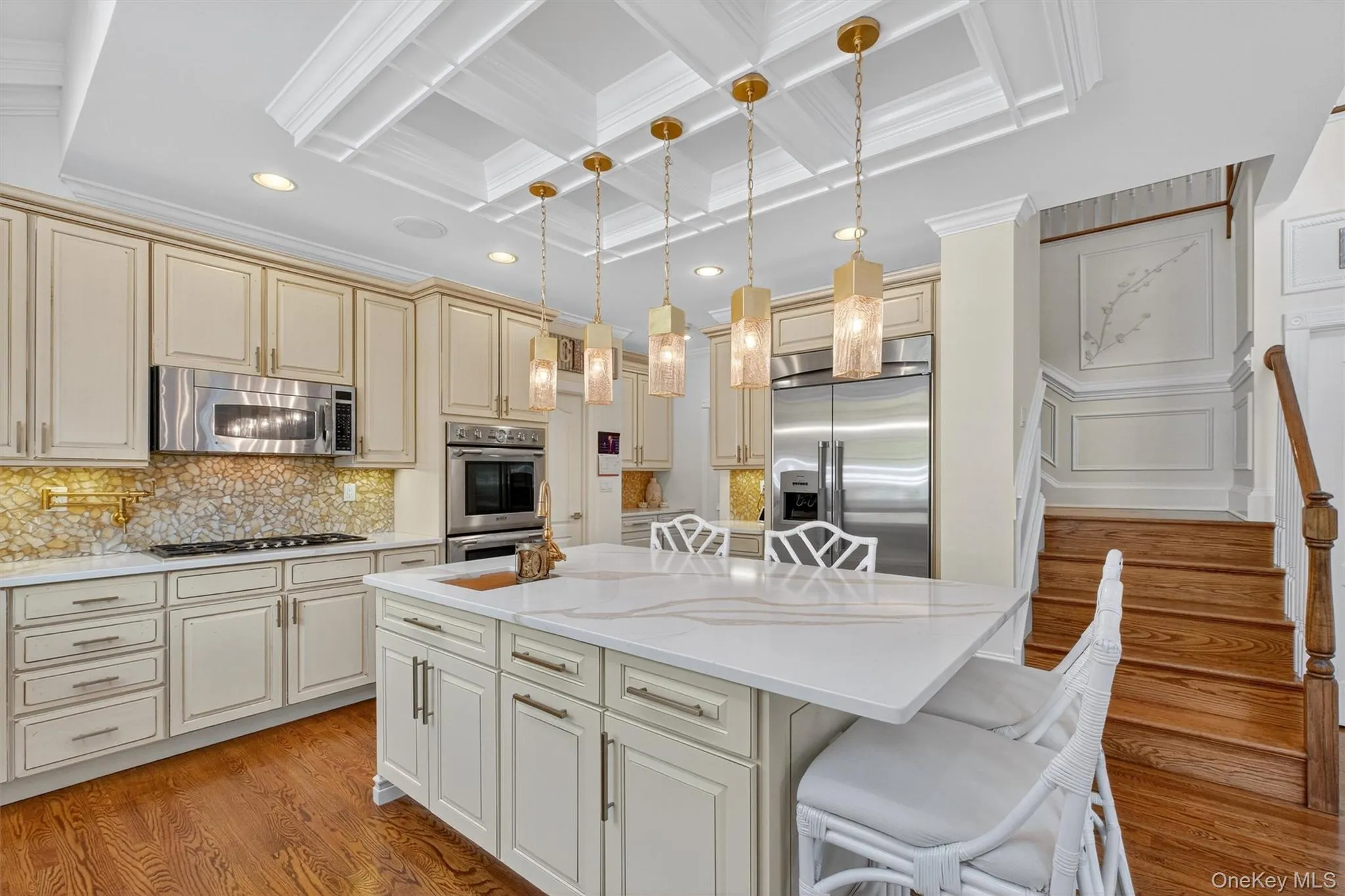 This kitchen is as functional as it is stunning, packed with every feature today’s homeowner could want. Highlights include a gas cooktop, microwave, double oven, garbage disposal, and a designer refrigerator seamlessly integrated into the off-white burnished custom cabinetry. Sparkling quartz countertops and tasteful lighting accents elevate the design, while the thoughtful layout makes cooking and entertaining effortless. As a bonus, a convenient staircase to the second floor ensures easy access—perfect for those late-night snacks. This kitchen is as functional as it is stunning, packed with every feature today’s homeowner could want. Highlights include a gas cooktop, microwave, double oven, garbage disposal, and a designer refrigerator seamlessly integrated into the off-white burnished custom cabinetry. Sparkling quartz countertops and tasteful lighting accents elevate the design, while the thoughtful layout makes cooking and entertaining effortless. As a bonus, a convenient staircase to the second floor ensures easy access—perfect for those late-night snacks.