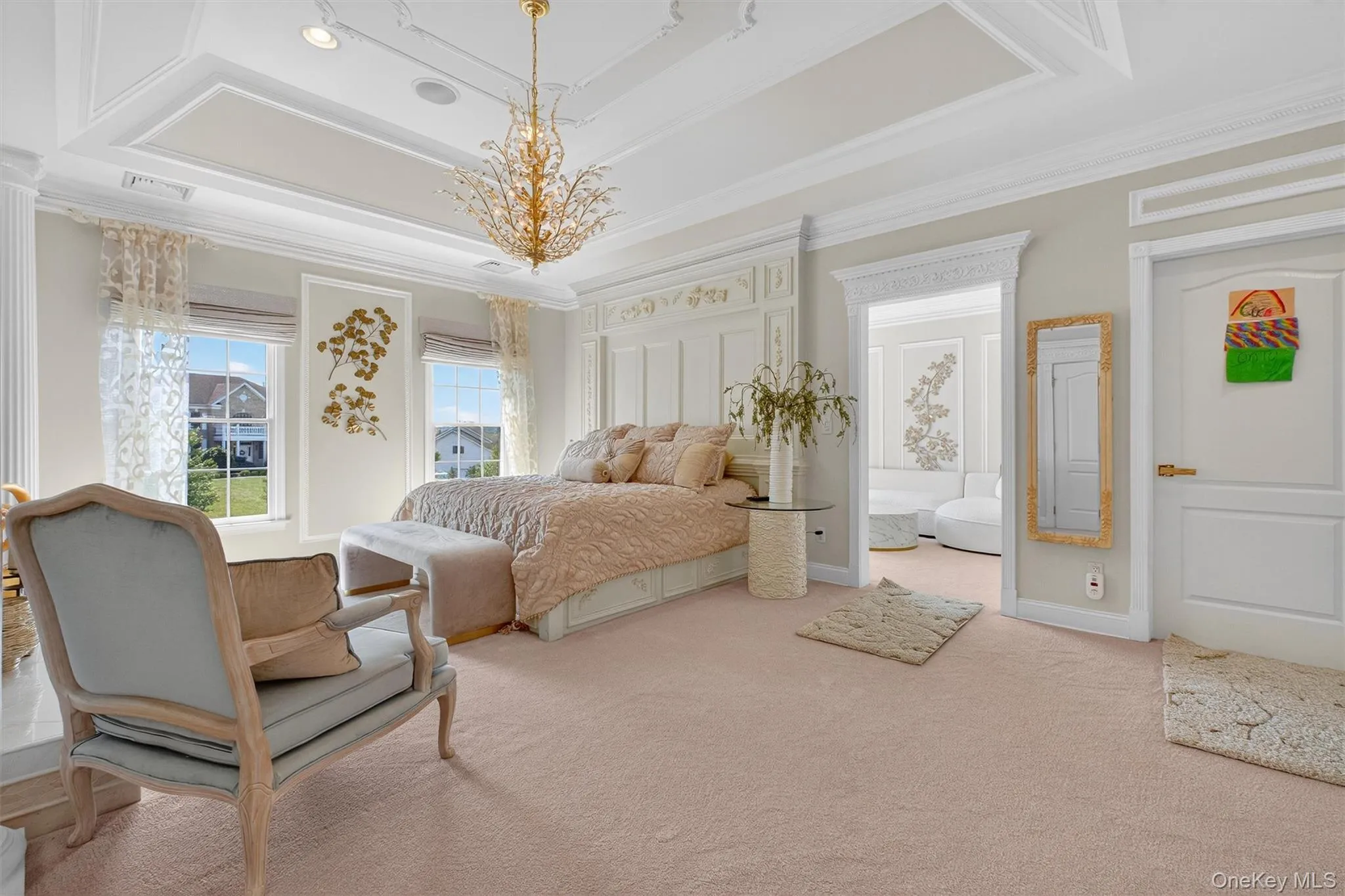 This enchanting master suite is a private retreat designed with elegance and comfort in mind. A tray ceiling with ornamental moldings adds architectural charm, while custom blinds and drapery frame the windows with sophistication. The room is warmed by plush soft pink carpeting, creating a serene and inviting atmosphere. Two His and Her custom closets with rich cabinetry provide abundant storage and organization, leading seamlessly into a spacious sitting room—the perfect spot to unwind, read, or enjoy a quiet escape. This suite offers both luxury and functionality, making it a true sanctuary within the home. This enchanting master suite is a private retreat designed with elegance and comfort in mind. A tray ceiling with ornamental moldings adds architectural charm, while custom blinds and drapery frame the windows with sophistication. The room is warmed by plush soft pink carpeting, creating a serene and inviting atmosphere. Two His and Her custom closets with rich cabinetry provide abundant storage and organization, leading seamlessly into a spacious sitting room—the perfect spot to unwind, read, or enjoy a quiet escape. This suite offers both luxury and functionality, making it a true sanctuary within the home.