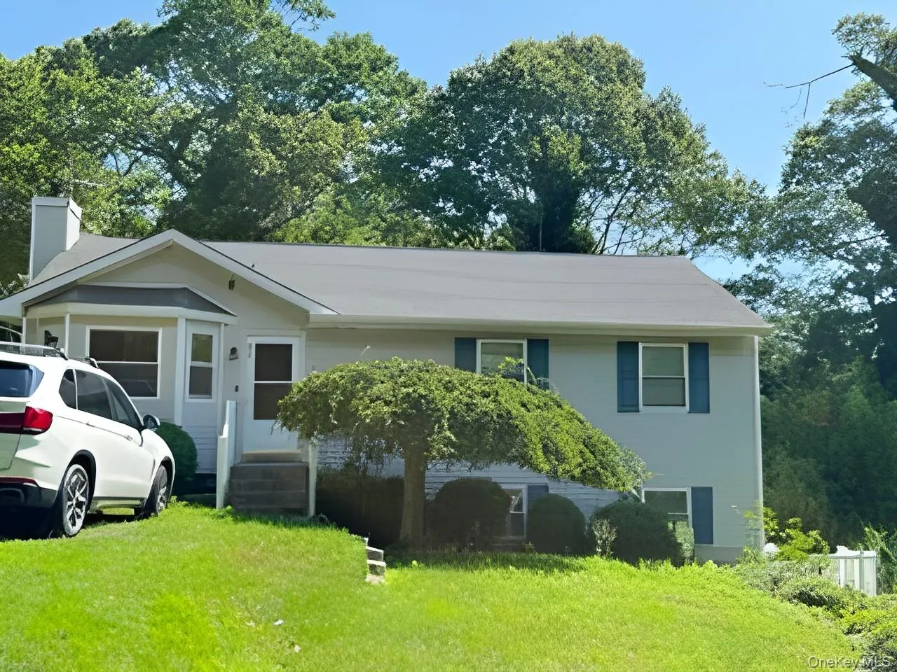 View of front of home featuring a front yard and a chimney View of front of home featuring a front yard and a chimney