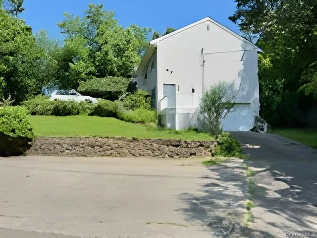 View of property exterior featuring asphalt driveway, a garage, and stucco siding View of property exterior featuring asphalt driveway, a garage, and stucco siding