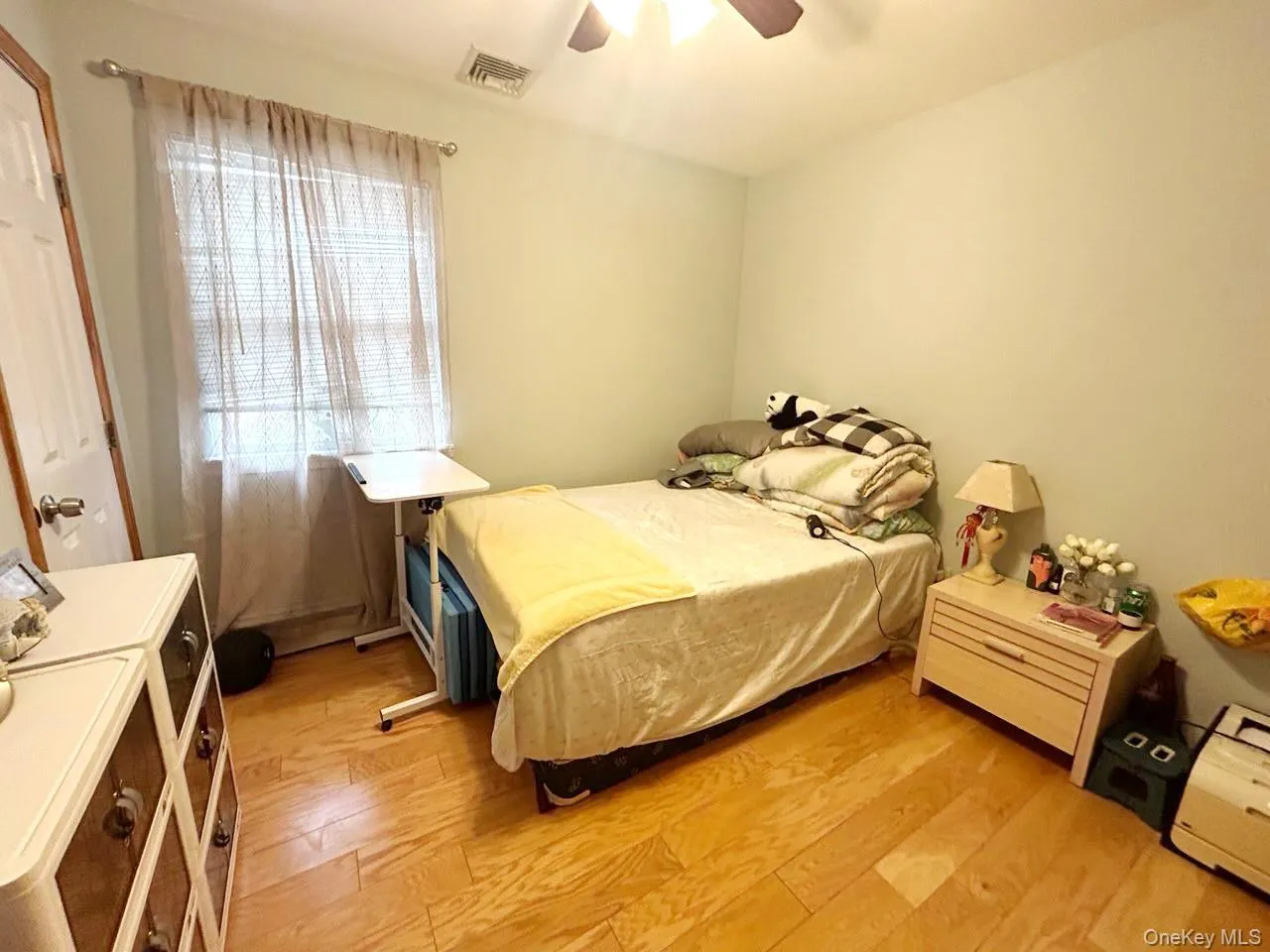 Bedroom with light wood finished floors and a ceiling fan Bedroom with light wood finished floors and a ceiling fan