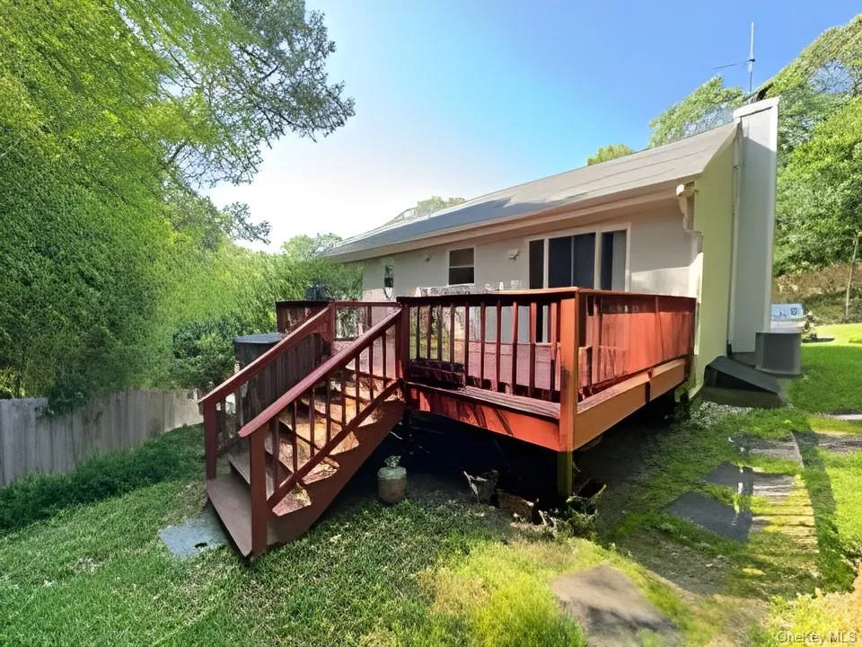 Rear view of property with a deck and a chimney Rear view of property with a deck and a chimney