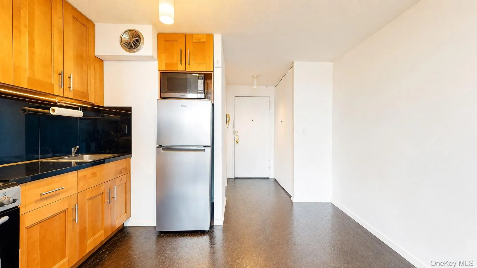 Kitchenette featuring Maple cabinetry, sleek Black Granite dark countertops, and stainless steel appliances Kitchenette featuring Maple cabinetry, sleek Black Granite dark countertops, and stainless steel appliances