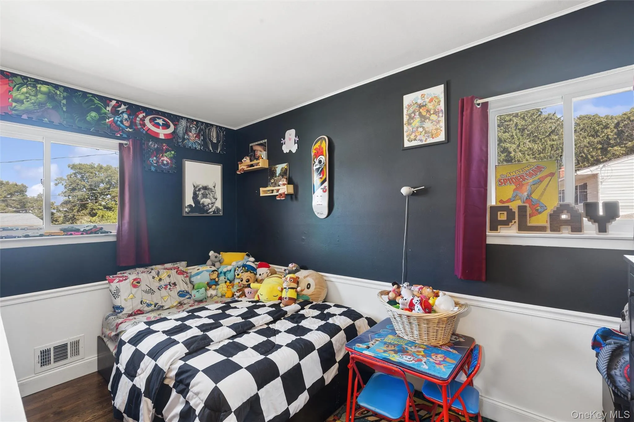 Two pane windows with exterior views, dark painted walls, white wainscoting, wood-finish flooring Two pane windows with exterior views, dark painted walls, white wainscoting, wood-finish flooring