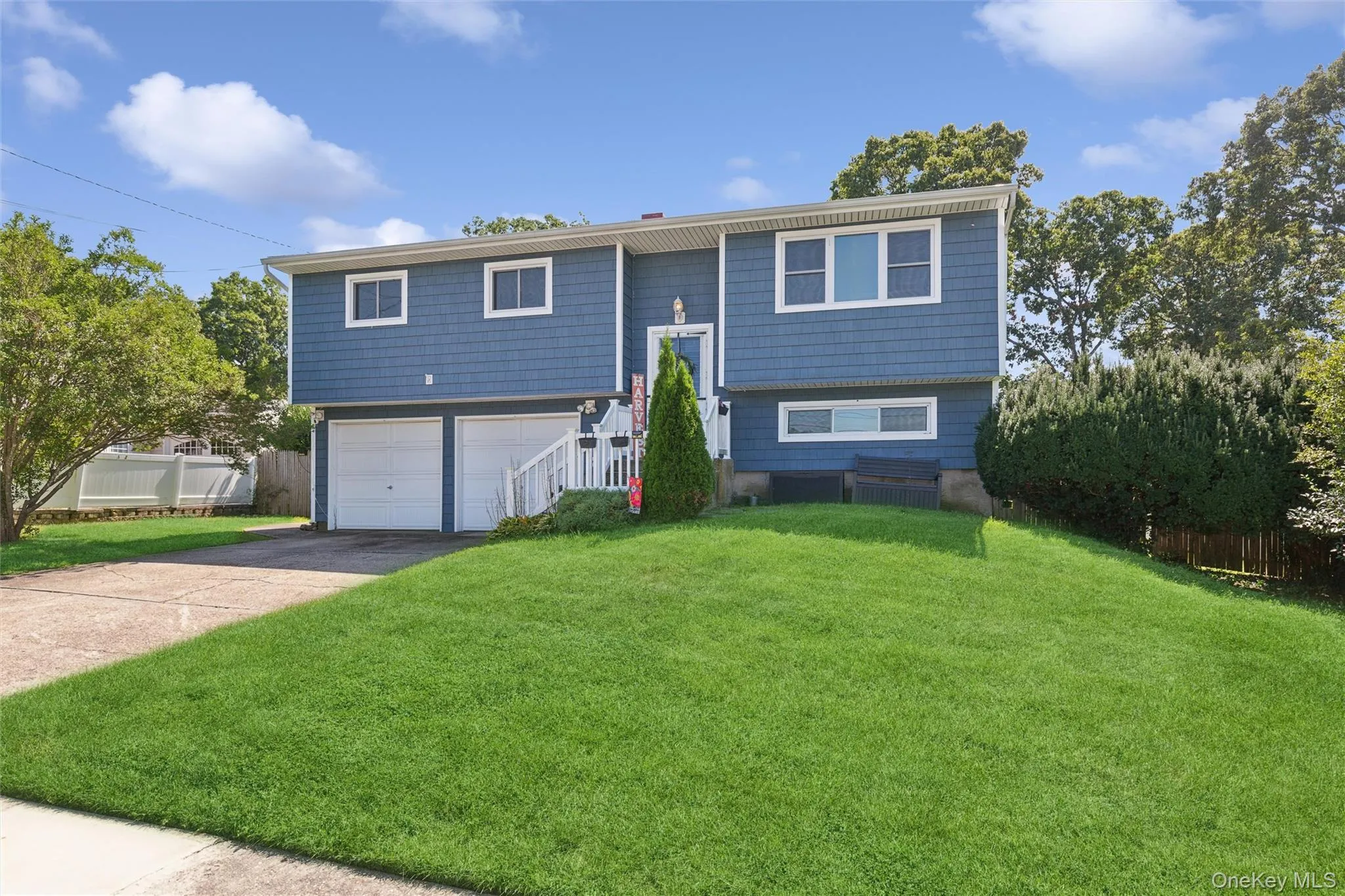 Split-level residence featuring blue shingle siding and a white trim Split-level residence featuring blue shingle siding and a white trim