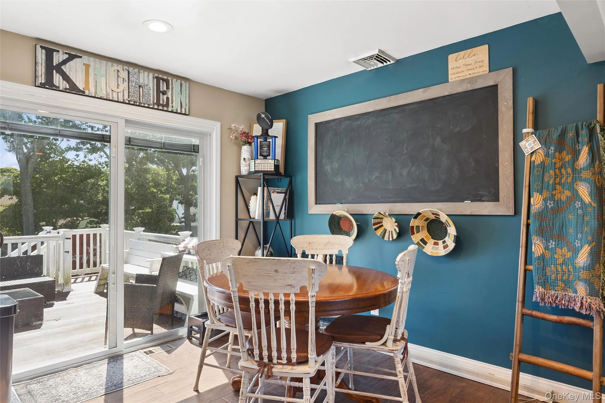 Sliding glass door access to a balcony with white railings, featuring wood-finish flooring and a ceiling-mounted light fixture Sliding glass door access to a balcony with white railings, featuring wood-finish flooring and a ceiling-mounted light fixture
