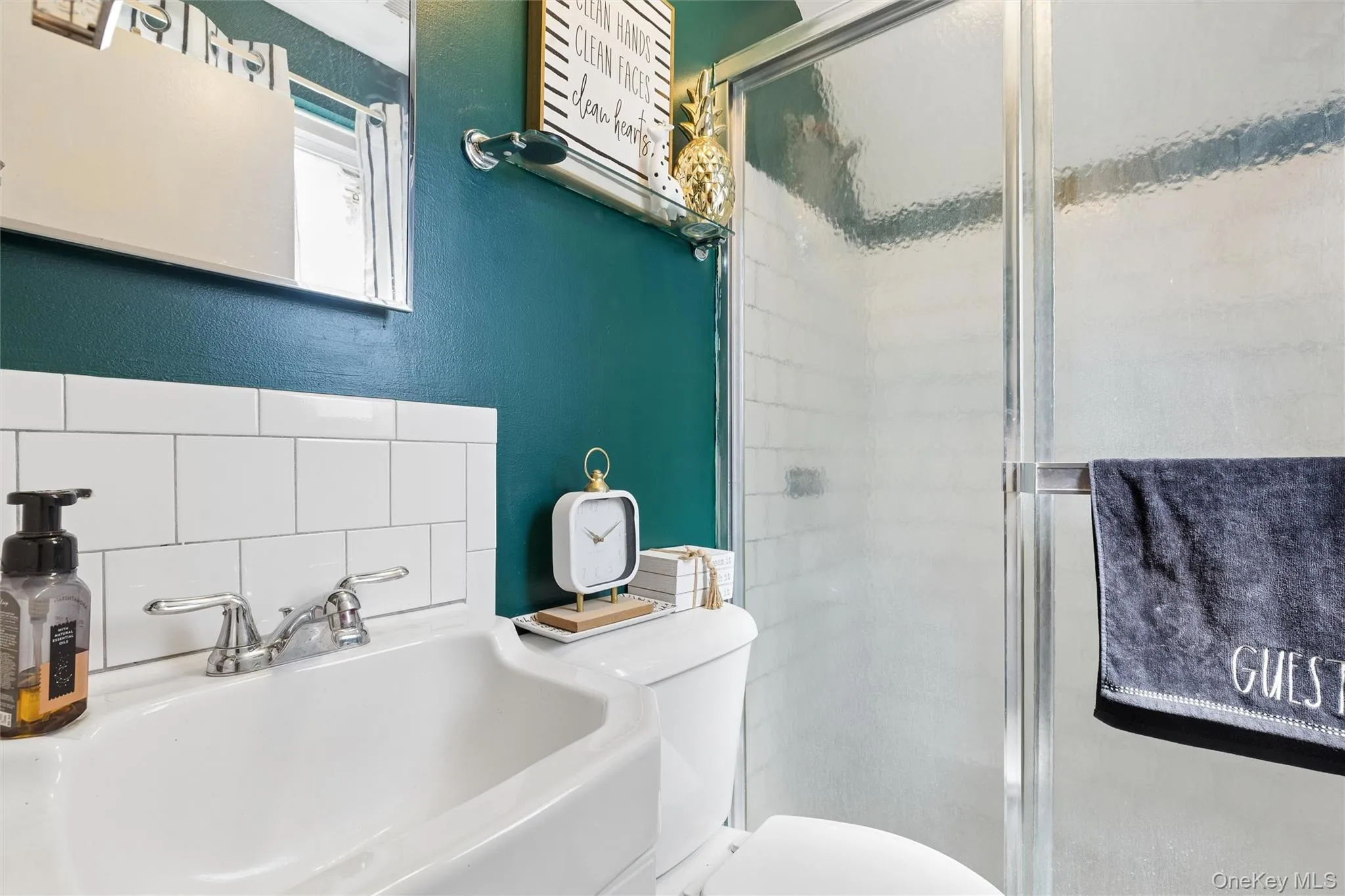 Shower enclosure with framed glass door, white subway tile surround, and a chrome towel bar Shower enclosure with framed glass door, white subway tile surround, and a chrome towel bar