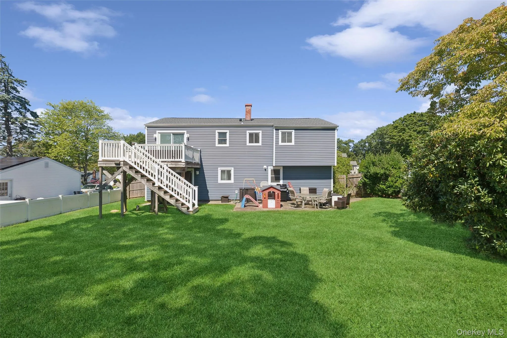 Expansive green lawn with a white privacy fence Expansive green lawn with a white privacy fence