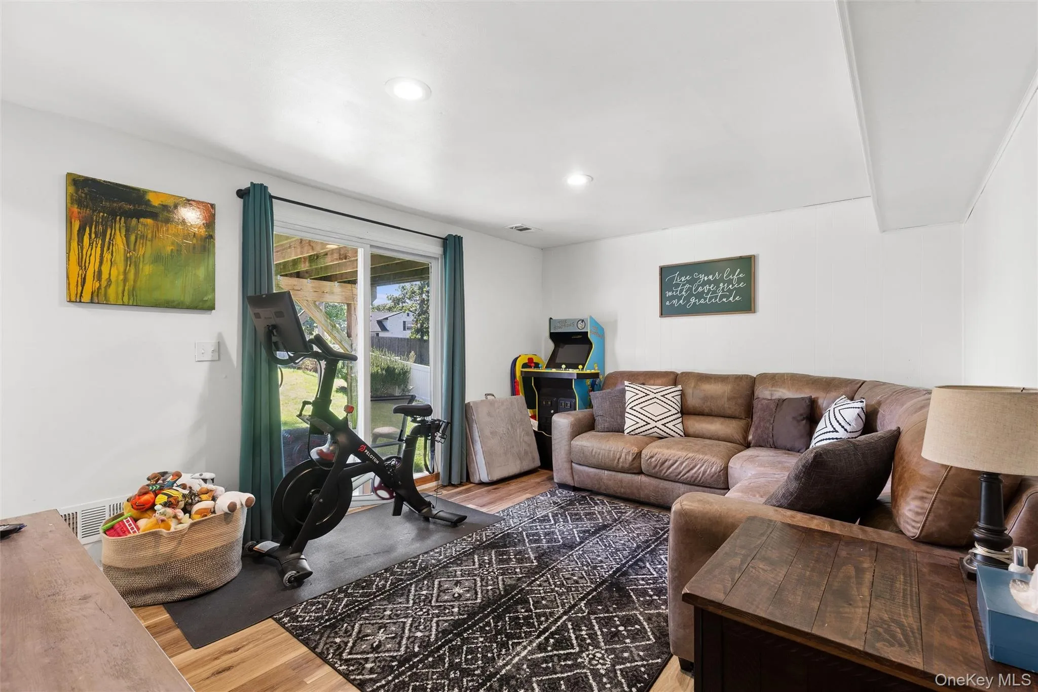 Recessed lighting, wood-finish flooring, sliding glass door, and white walls Recessed lighting, wood-finish flooring, sliding glass door, and white walls