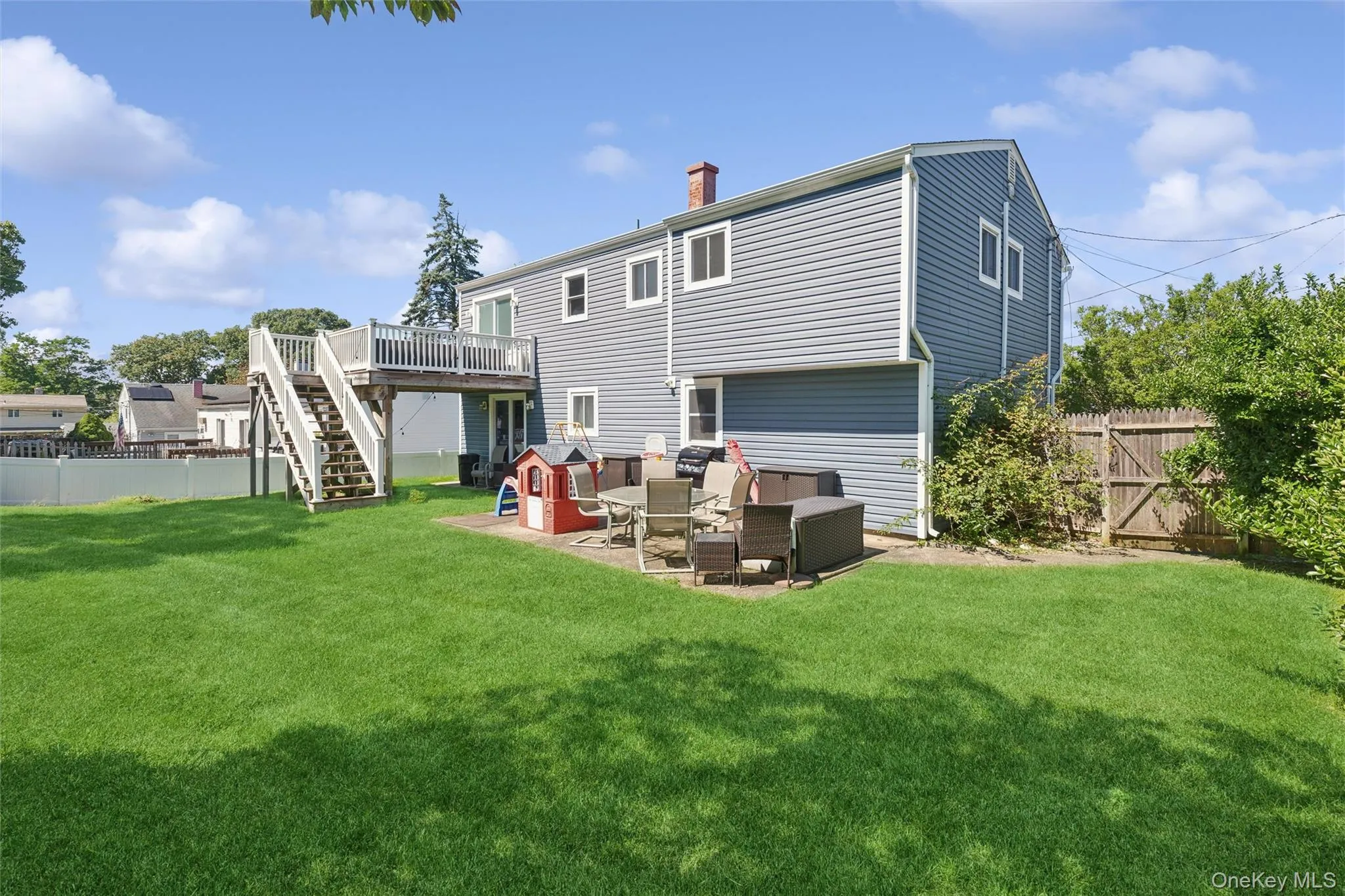 Expansive green lawn, elevated wood deck with stairs, lower-level patio, wood privacy fencing Expansive green lawn, elevated wood deck with stairs, lower-level patio, wood privacy fencing