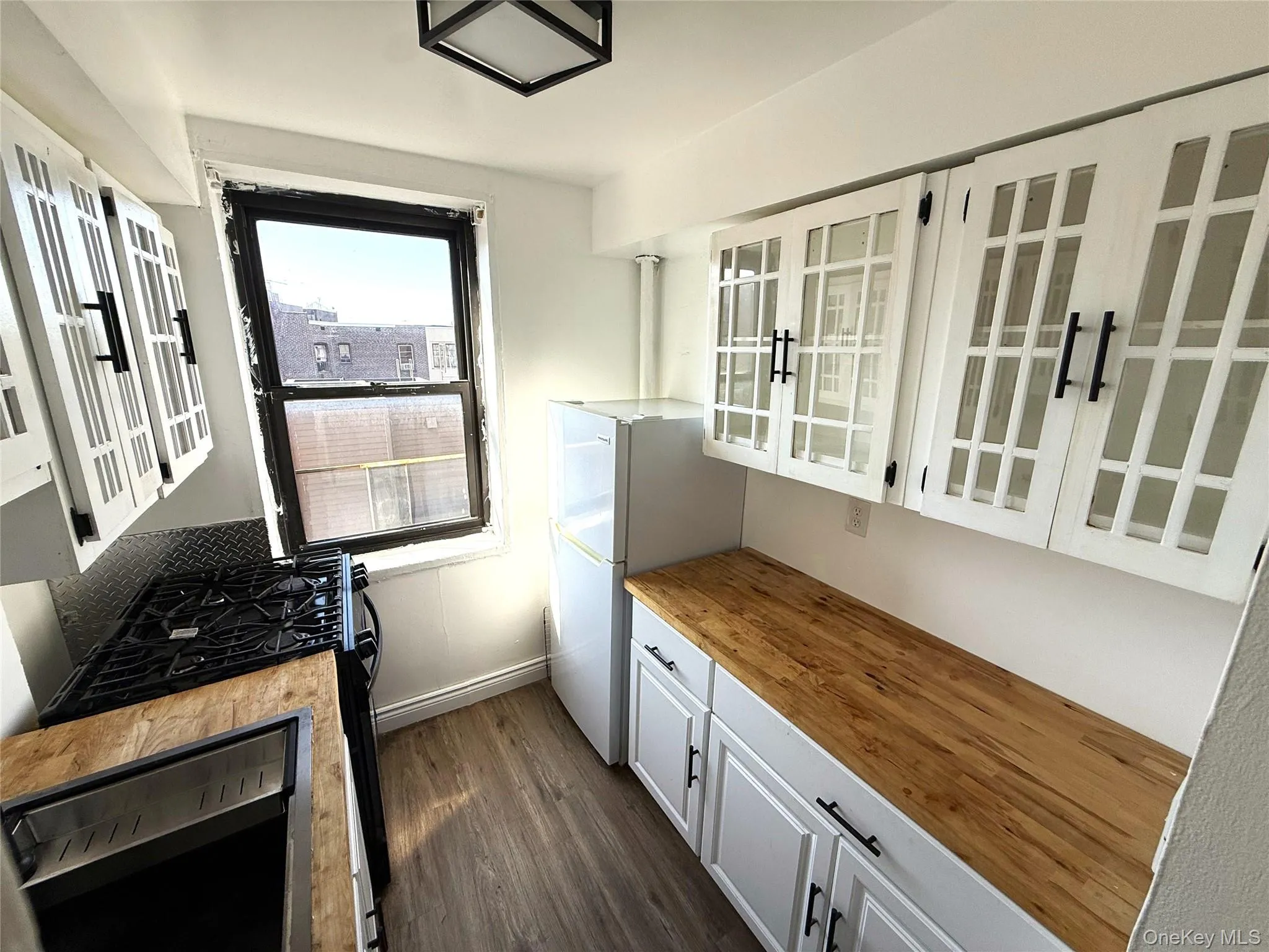 Updated kitchen with wooden counters, glass-paned cabinetry, and appliances. Updated kitchen with wooden counters, glass-paned cabinetry, and appliances.