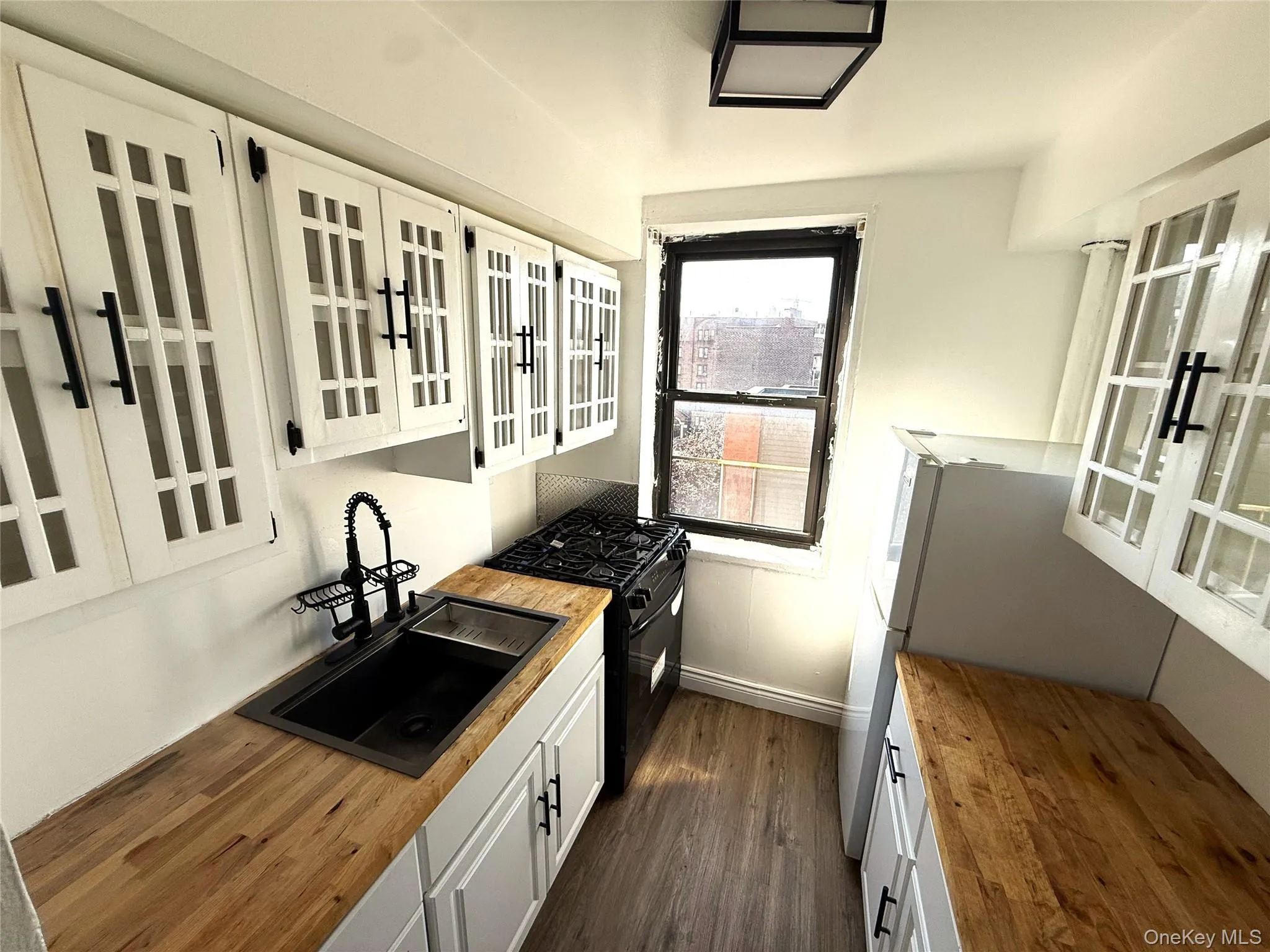 Updated kitchen with wooden counters, glass-paned cabinetry, and appliances. Updated kitchen with wooden counters, glass-paned cabinetry, and appliances.