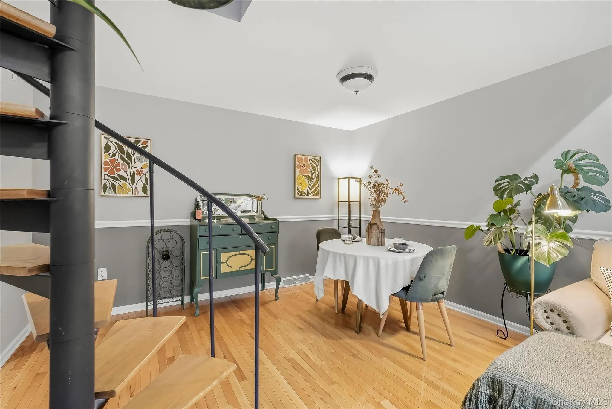 Dining area framed by the spiral staircase and warm natural light. Dining area framed by the spiral staircase and warm natural light.