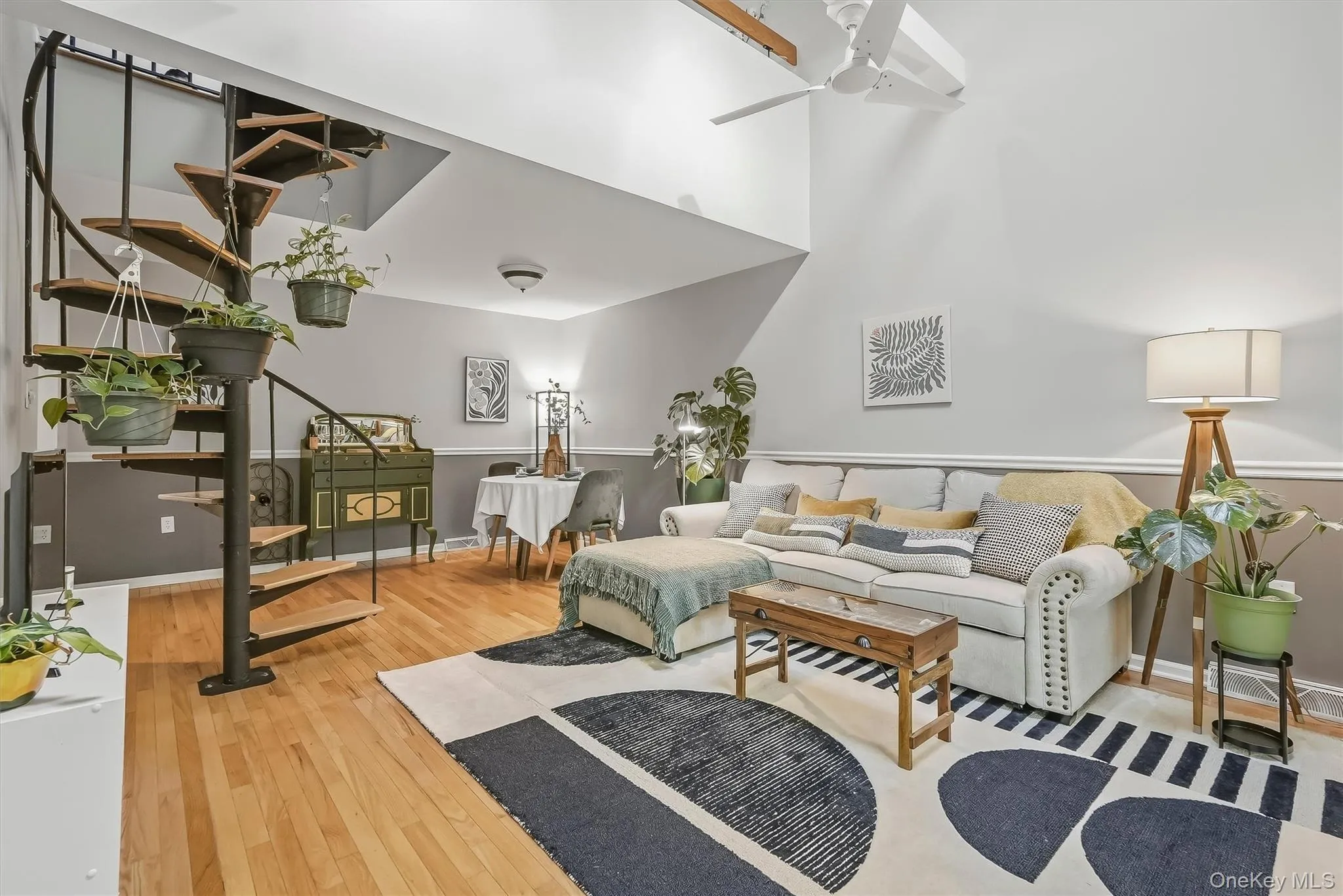 Bright living room with hardwood floors, fireplace, and dramatic spiral staircase. Bright living room with hardwood floors, fireplace, and dramatic spiral staircase.