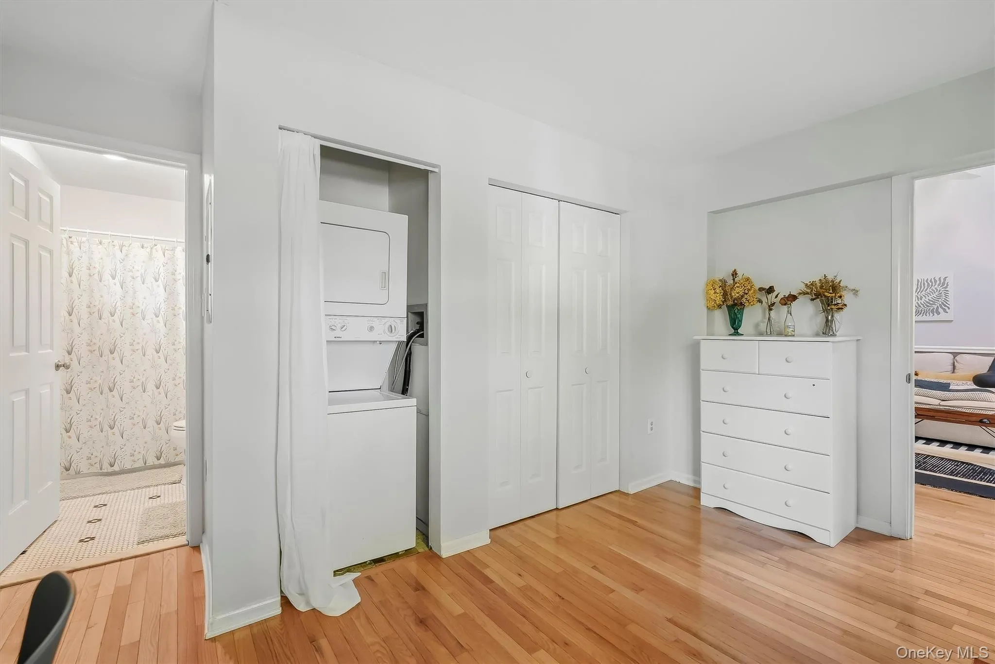 Bedroom with hardwood floors, generous closet space, and in-unit laundry. Bedroom with hardwood floors, generous closet space, and in-unit laundry.