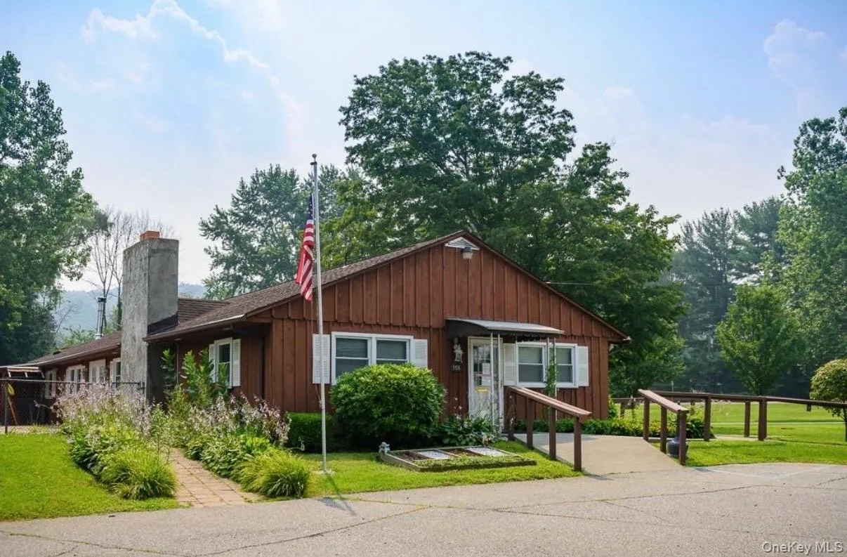 Park office/clubhouse wood-sided exterior with a prominent stone chimney. Park office/clubhouse wood-sided exterior with a prominent stone chimney.