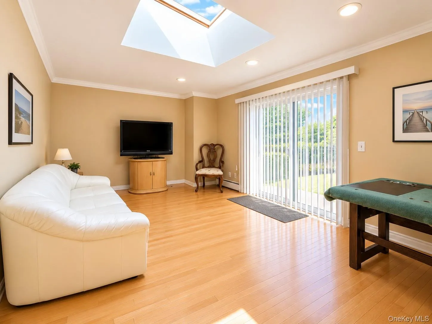 Hardwood flooring, crown molding, a skylight, recessed lighting, and a sliding glass door Hardwood flooring, crown molding, a skylight, recessed lighting, and a sliding glass door