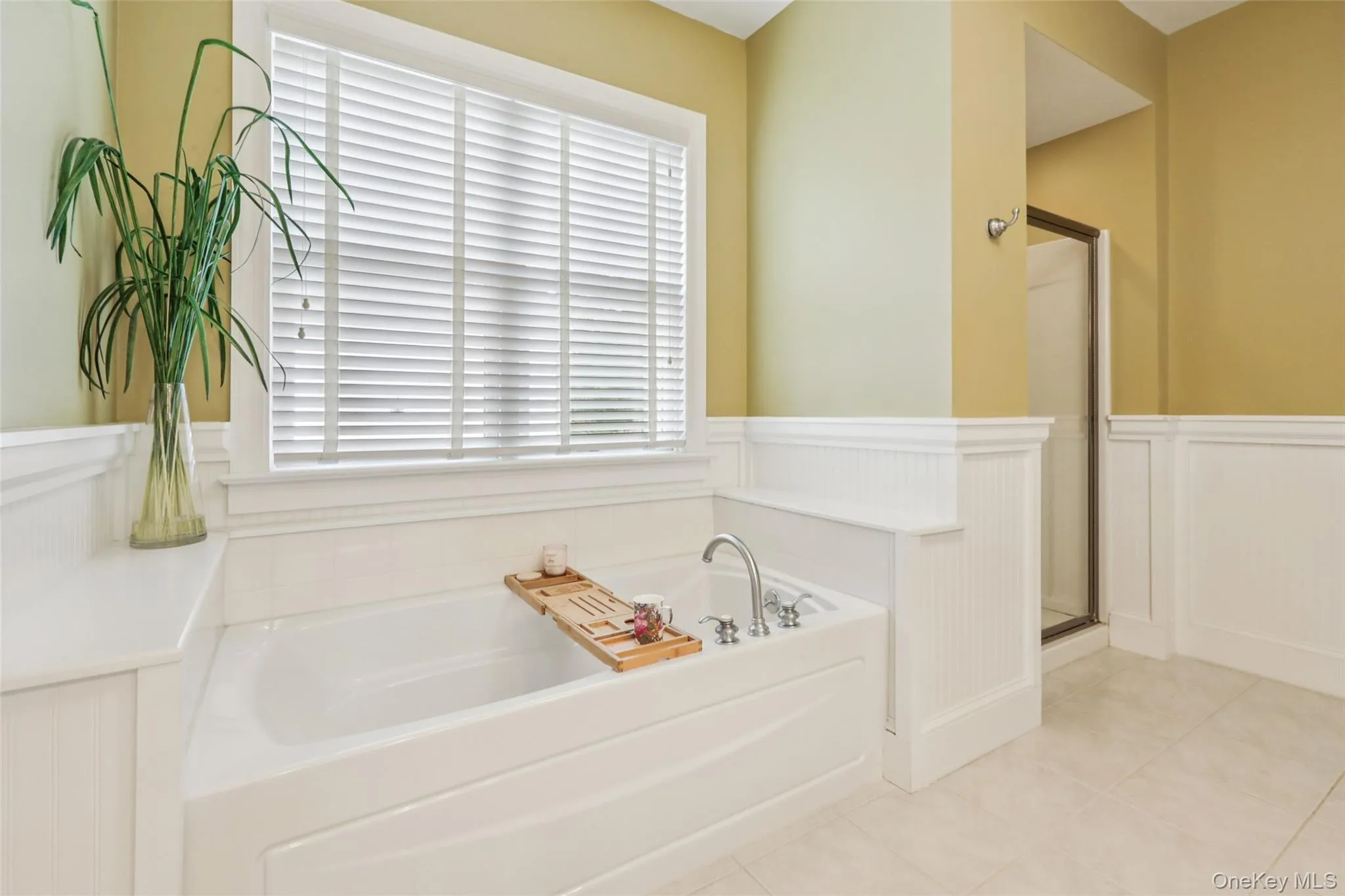 Full bath with wainscoting, a soaking tub, and a walk-in shower Full bath with wainscoting, a soaking tub, and a walk-in shower