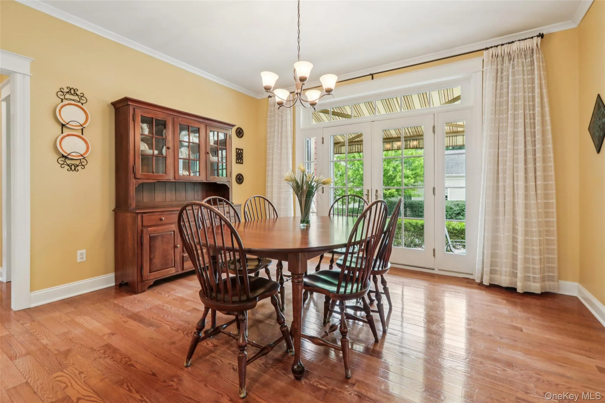 Dining space with crown molding, a chandelier, and french doors leading to the side patio Dining space with crown molding, a chandelier, and french doors leading to the side patio